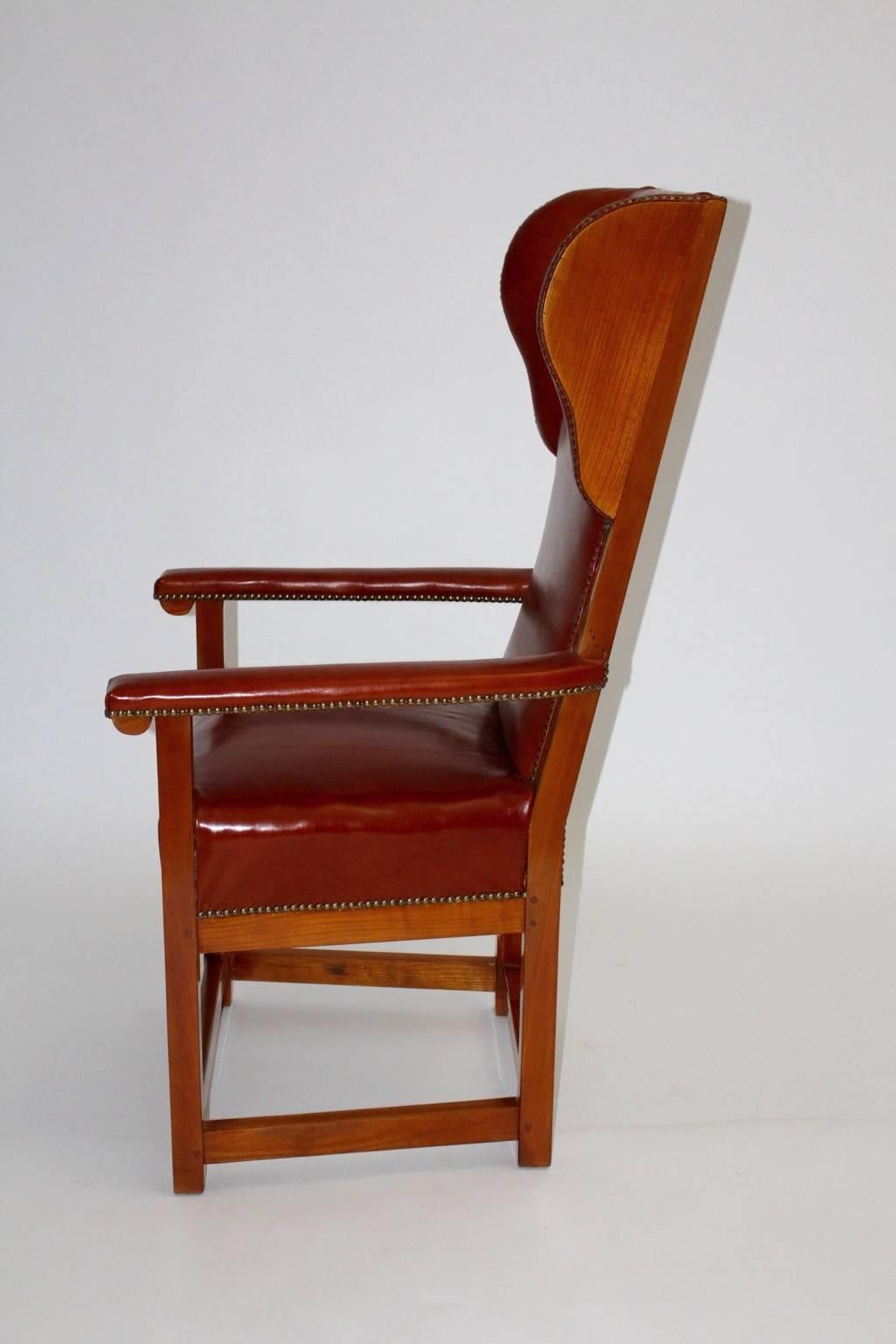 The Biedermeier wingback chair is made of solid cherrywood carefully cleaned and newly hand-polished.
Furthermore the renewed upholstery is covered with cognac leather and decorated with nails.

The condition of the Biedermeier wingback chair is