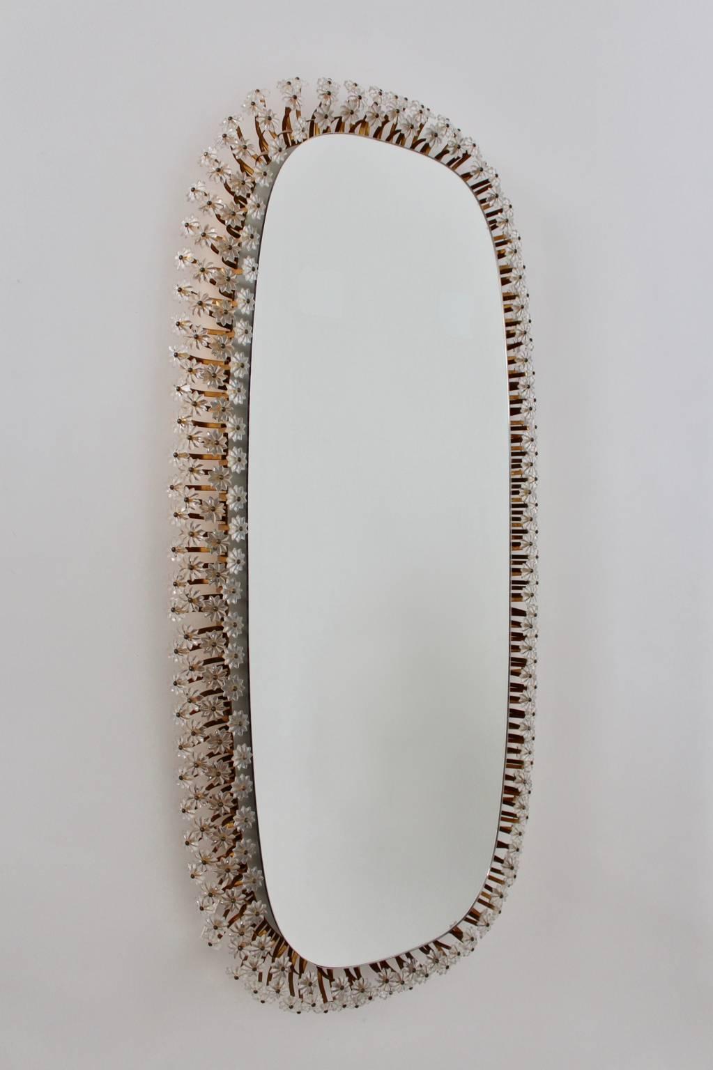 Huge backlit wall mirror by Emil Stejnar, 1950s, Austria.

The fantastic illuminated mirror is surrounded at the edge with small glass flowers with gilded metal stems.

You can hang up the wall mirror broadside or lengthways.
The blaze is very