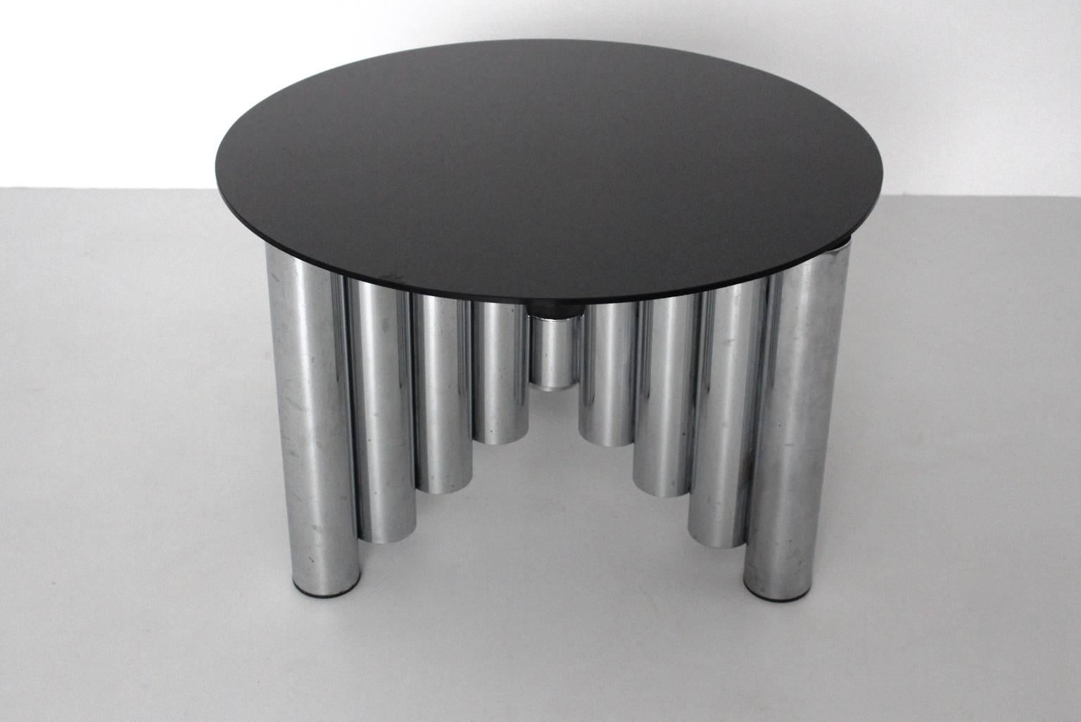 Table basse ou table de canapé vintage Mid Century Modern avec une base chromée et un plateau en verre de couleur noire.
Alors que la base en tube d'acier chromé est en bon état avec des signes d'âge, le plateau en verre noir présente de fines