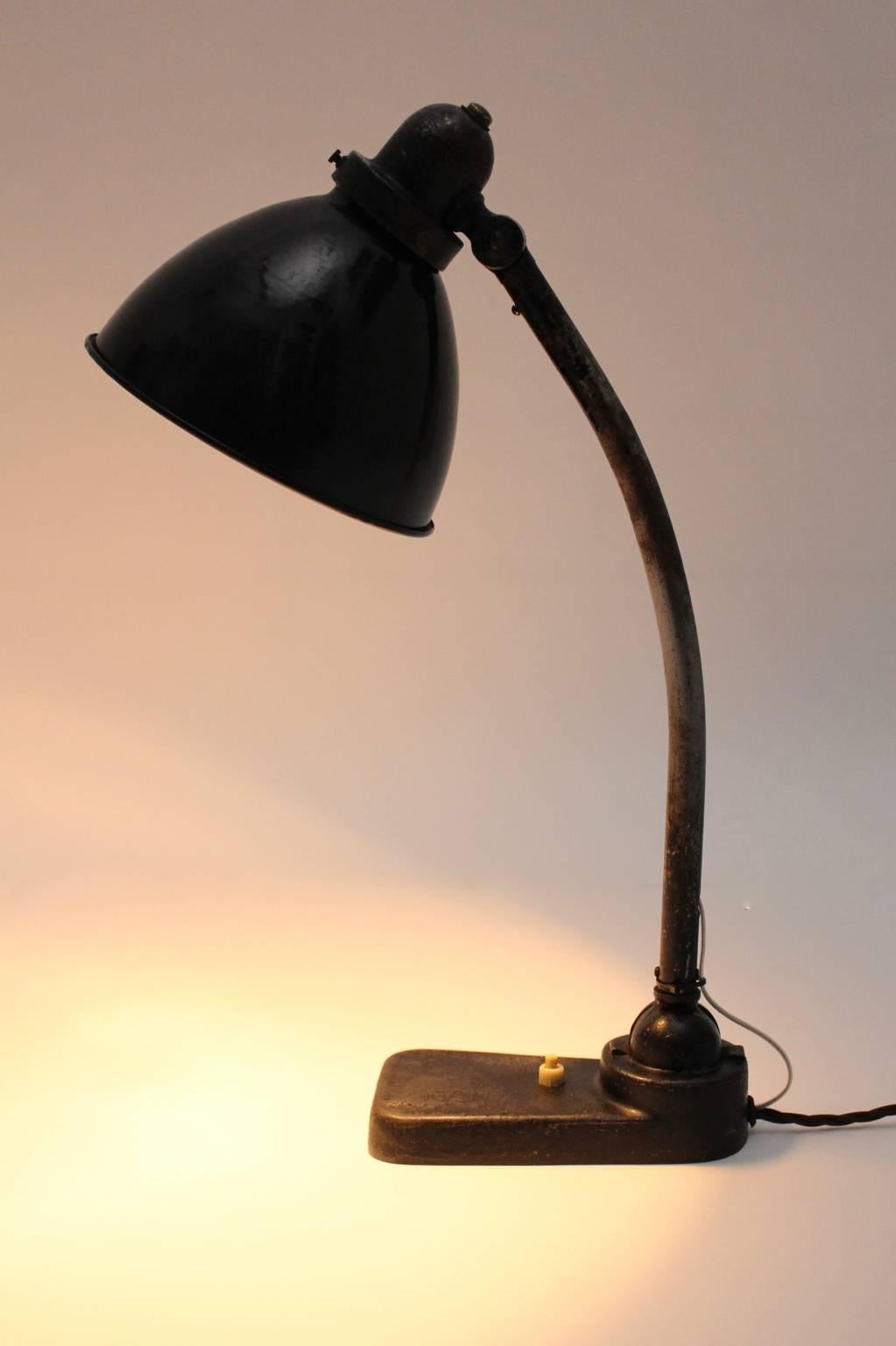 Bauhaus black lacquered vintage metal table lamp by Christian Dell 1930s, Germany with white enamel interior.
The table lamp or architect lamp was made of metal black lacquered, furthermore the shade is inside white enameled.
The stem is adjustable