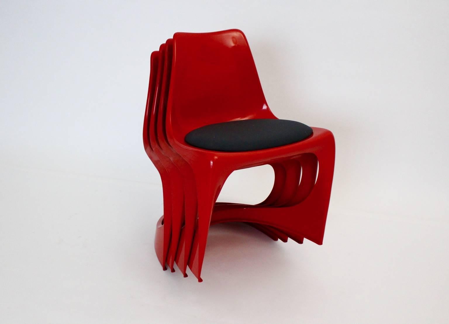 Space Age four ( 4 ) red plastic vintage dining chairs  by Steen Ostergaard 1966 for Cado Norway 1971.
These wonderful red 4 ( four ) dining chairs from plastic show a black textil upholstery.
Labeled underneath
Possible to stack the chairs. These