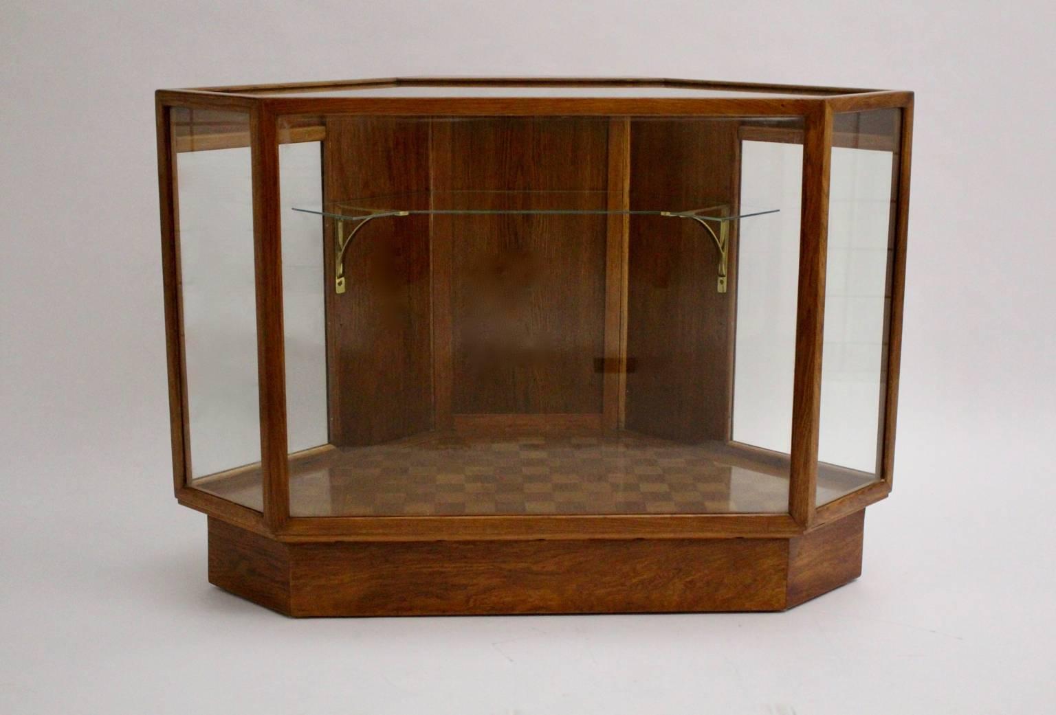 Art deco vintage showcase or vitrine from solid oakwood with brass details, circa 1920 Austria.
While one door shows a brass button to open the showcase easily and so to present your showpieces.
The showcase has seven glass panes for a good insight