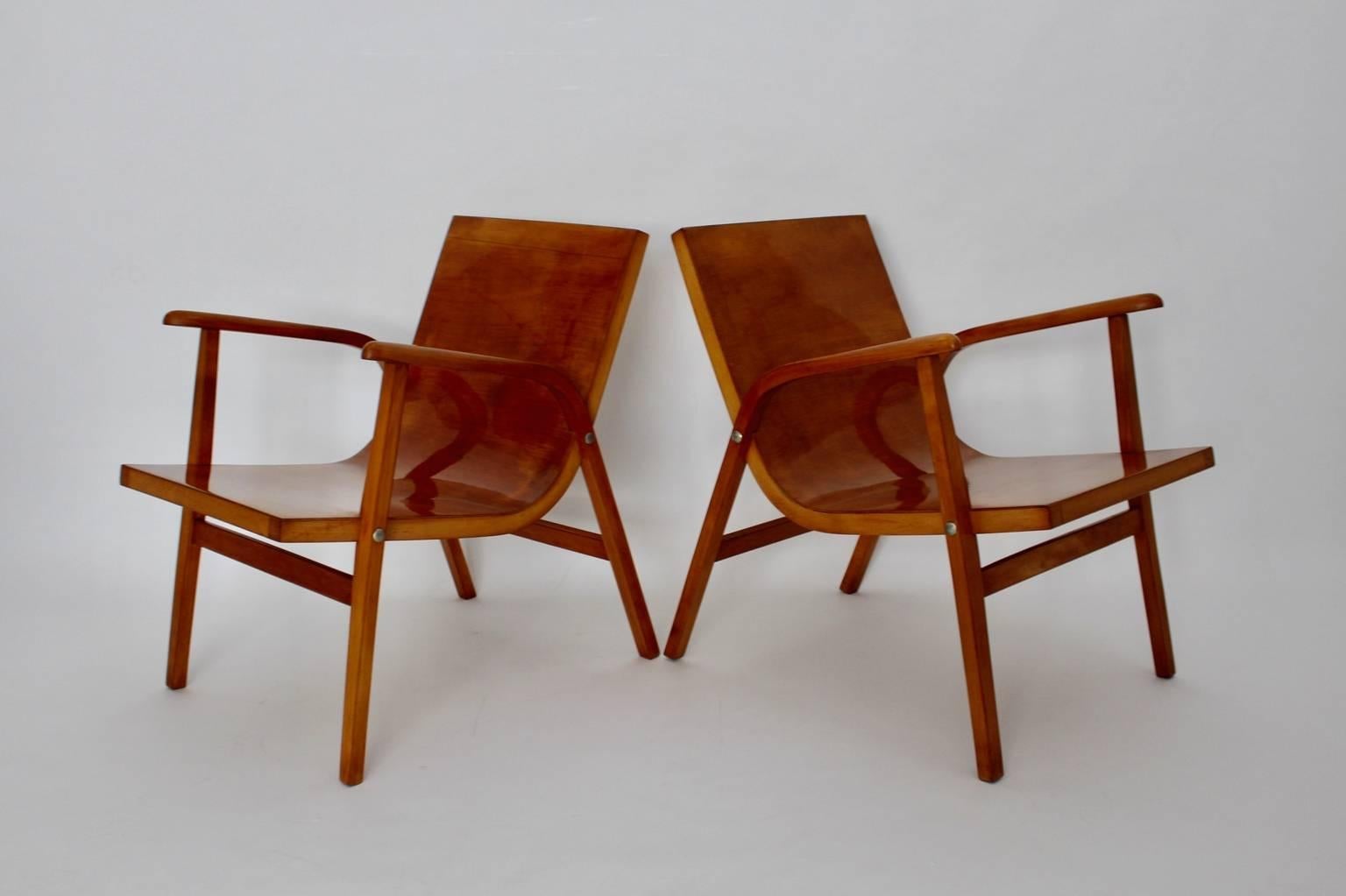 Mid Century Modern vintage pair of lounge chairs from beech designed by Roland Rainer, Vienna 1952 for the Cafe Ritter in Vienna, and manufactured by Emil & Alfred Pollak, Vienna.

The simple and chic lounge chairs are made of solid bent beechwood