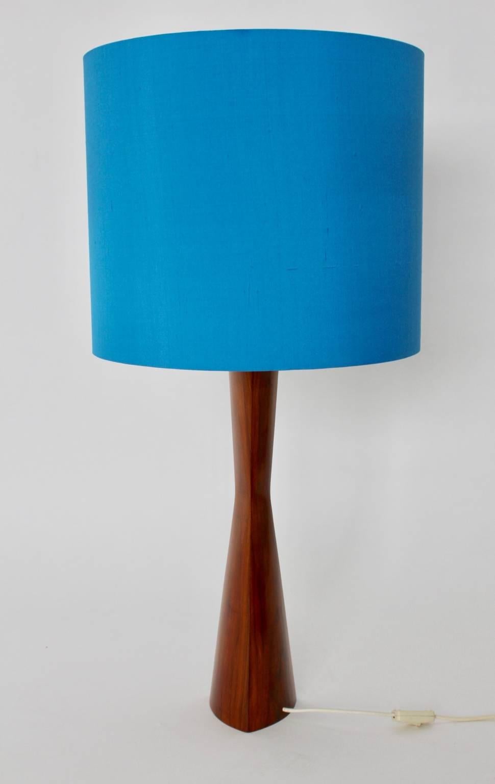 A Scandinavian modern teak table lamp or floor lamp, which shows a newly hand-polished base and a renewed lampshade in its original shape. The lamp shade is covered with an amazing blue silk fabric. 
Two sockets for E 27 bulbs and an on/off