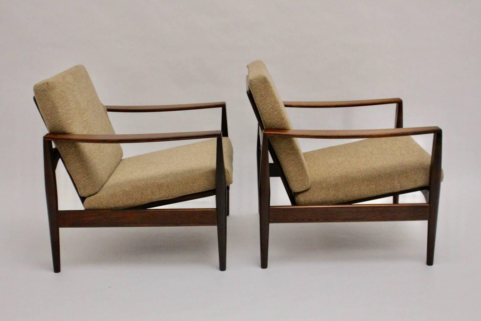 Scandinavian Modern vintage chairs from teak designed by Arne Wahl Iversen, 1960, Denmark.
The teak lounge chairs show reupholstered loose cushions covered with soft inviting textile fabric in brown pastel color tone.
While the frame is shellac