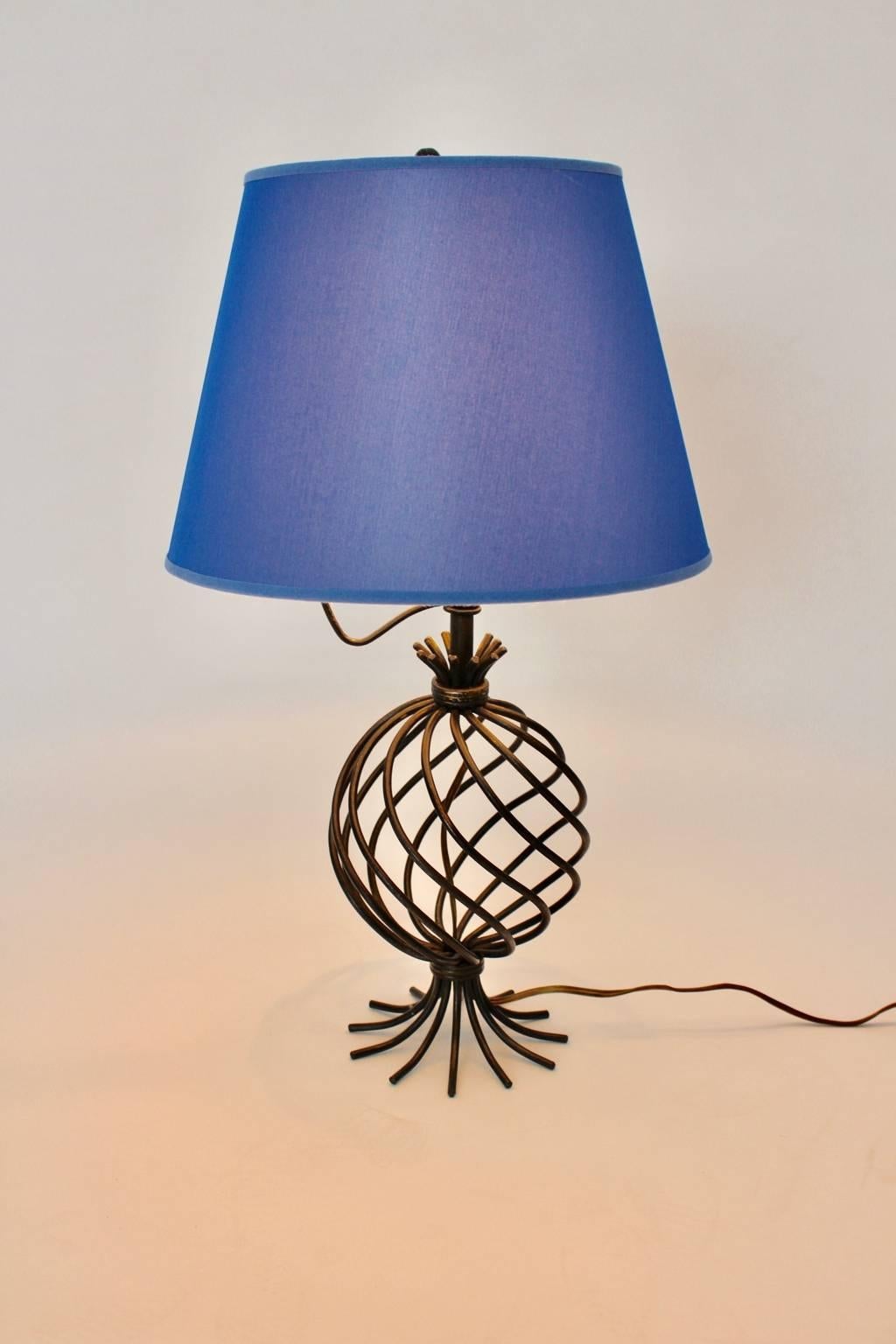 Moderne Vintage-Tischlampe aus Metall im Stil von Jean Royere mit einem erneuerten blauen Lampenschirm aus Textilgewebe und einem runden schwarz lackierten Metallsockel
Die Tischleuchte wird mit einer E 27-Glühbirne betrieben und verfügt über einen