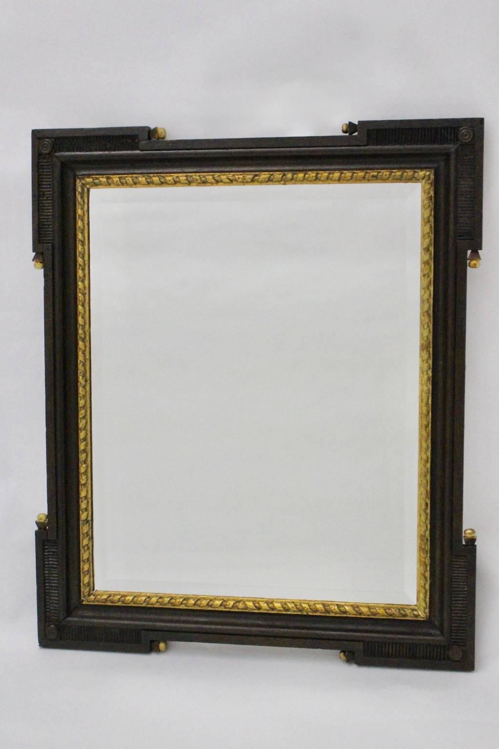 Antique Wall Mirror from hand-carved dark brown solid oakwood frame  with golden details as golden bullets and carved details with a great patina.
An amazing wall mirror in rectangular shape with a facetted renewed mirror glass.
The style of this