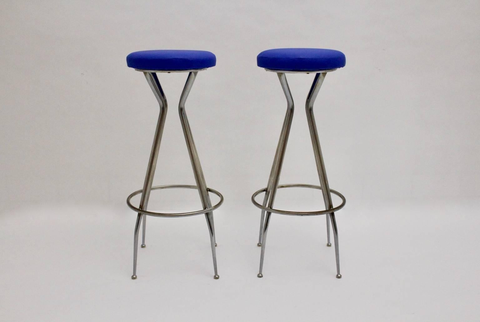 Mid Century Modern vintage set of 2 barstools 1950s Austria.
While the base from chromed tube steel the seats are covered with blue faux leather.
The condition is good.
The seats are in very good condition. The base shows some signs of age and use