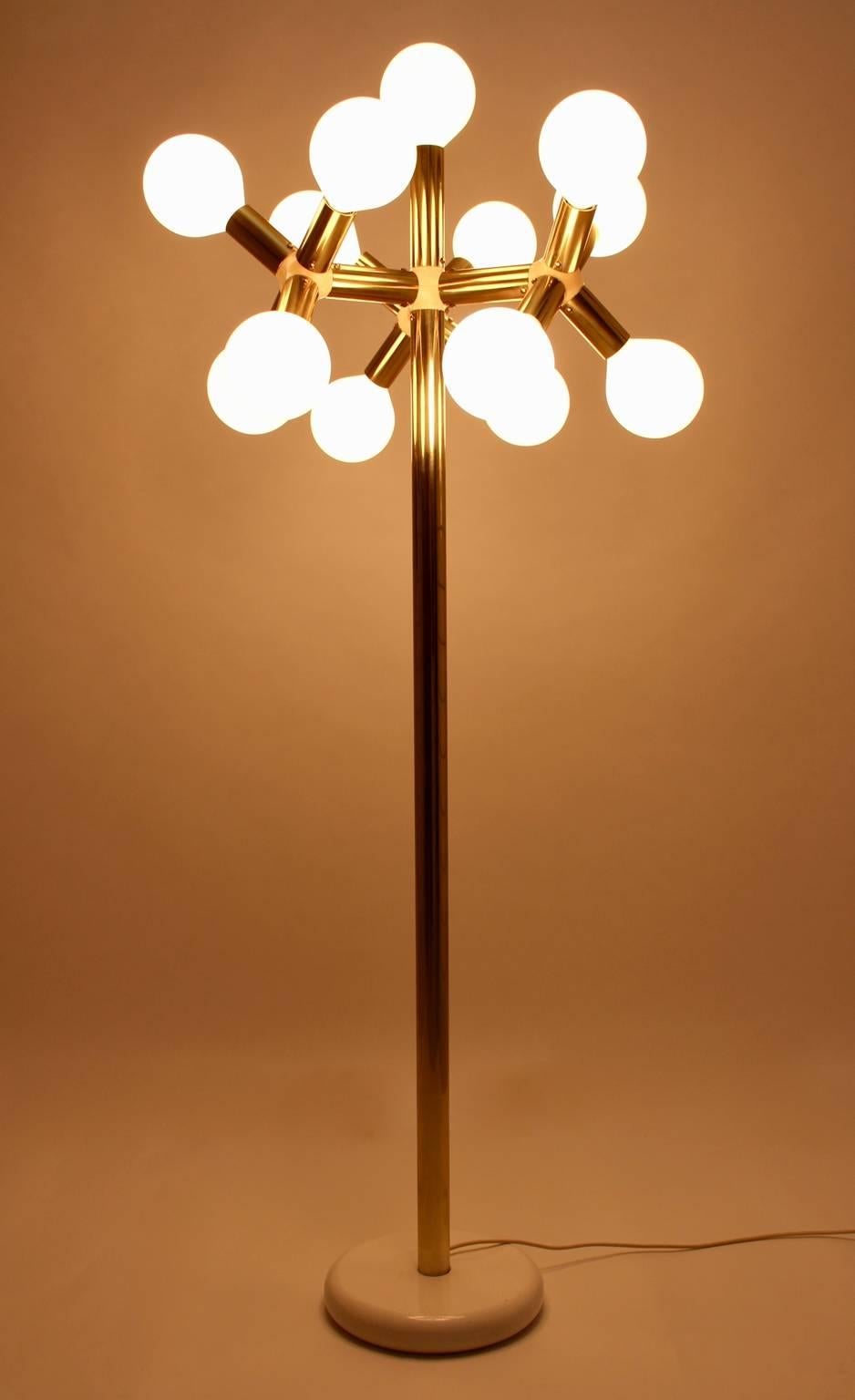 Brassed metal atomic floor Lamp designed by the Swiss Designer Duo Trix & Robert Haussmann, 1960s executed by Swisslamp International.
The base was made of metal white enameled furthermore the tube stand was made of brass.
The brass arms and 13 opal