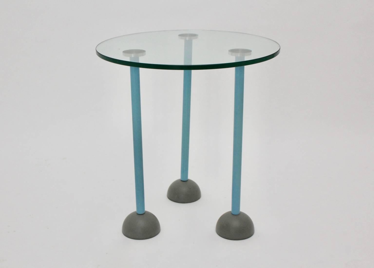This presented three-legged modernist vintage side table was designed by Ettore Sottsass attributed 1985, Italy.
This side table has three legs in the color turquoise. Each of the feet feature a plastic cup and a wheel.
The feet are screwed in metal