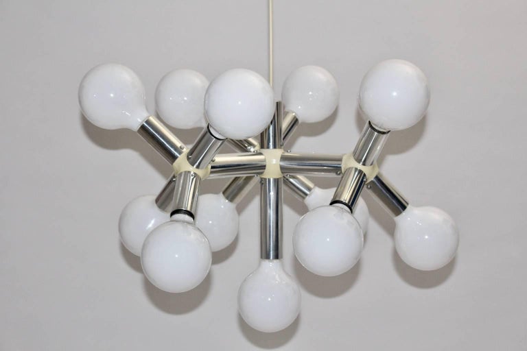 Mid Century Modern vintage atomic chandelier designed by Robert Haussmann and executed by Swiss Lamp International.
The tubes were made of chromed aluminium and feature plastic connections.
The chandelier has 13 sockets for E 27 bulbs.
Measure: The