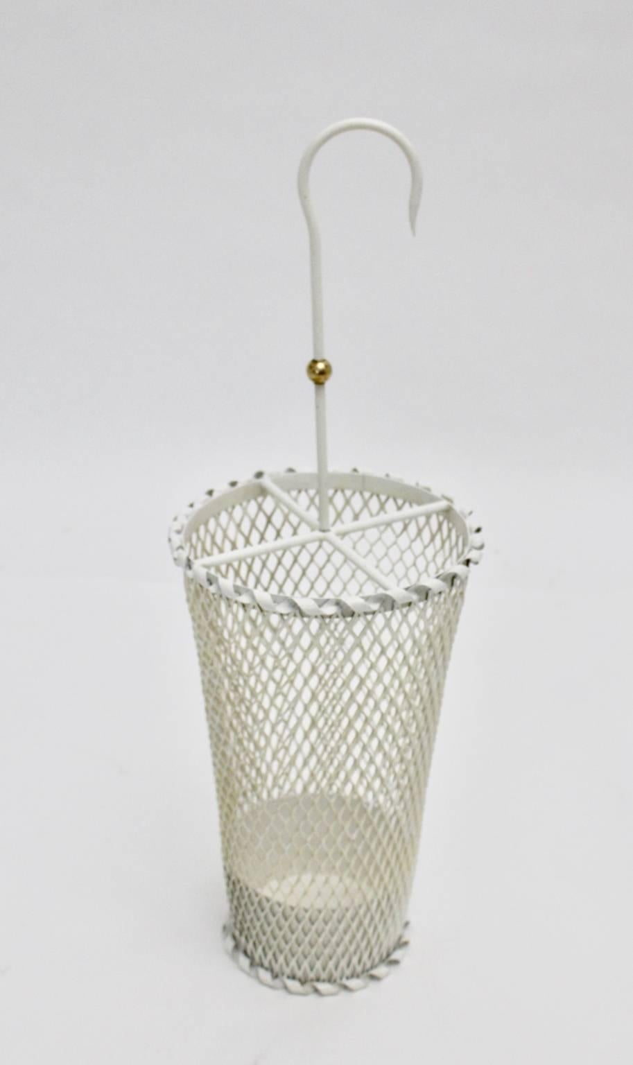 This very charming umbrella stand was designed by Mathieu Matégot and executed by Ateliers Matégot in the 1950s.
The umbrella stand was made of perforated white metal and features a very nice brass ball on the handle.
The condition is very good