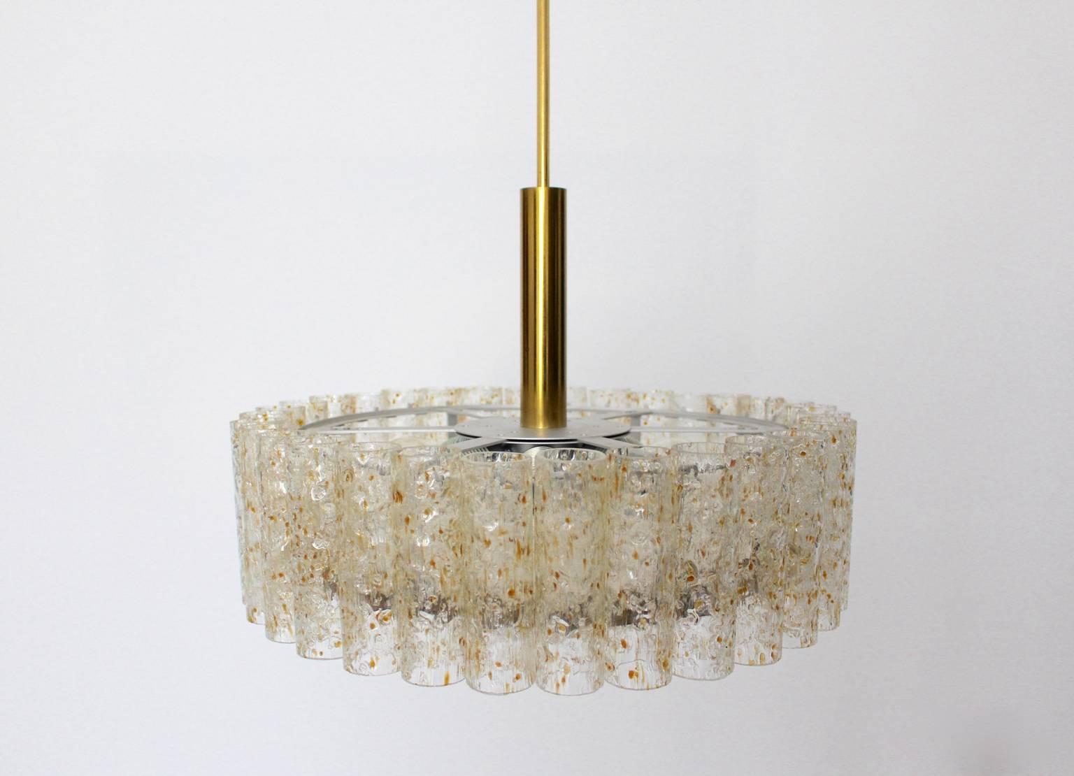 Mid century modern vintage textured glass chandelier or pendant,  which features 32 pieces of textured glass tubes and lights with six E 27 bulbs.The metal frame was silver enameled.
The chandelier was designed and manufactured by Doria Leuchten,