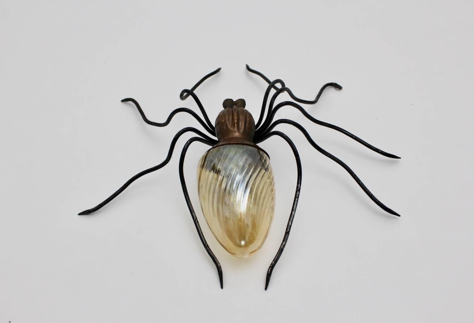 Mid-Century Modern wall lamp shaped like a spider.
The legs were made of metal wire, the body was made of copper with a yellow grooved glass shade.
It lights with a bulb E 14.
