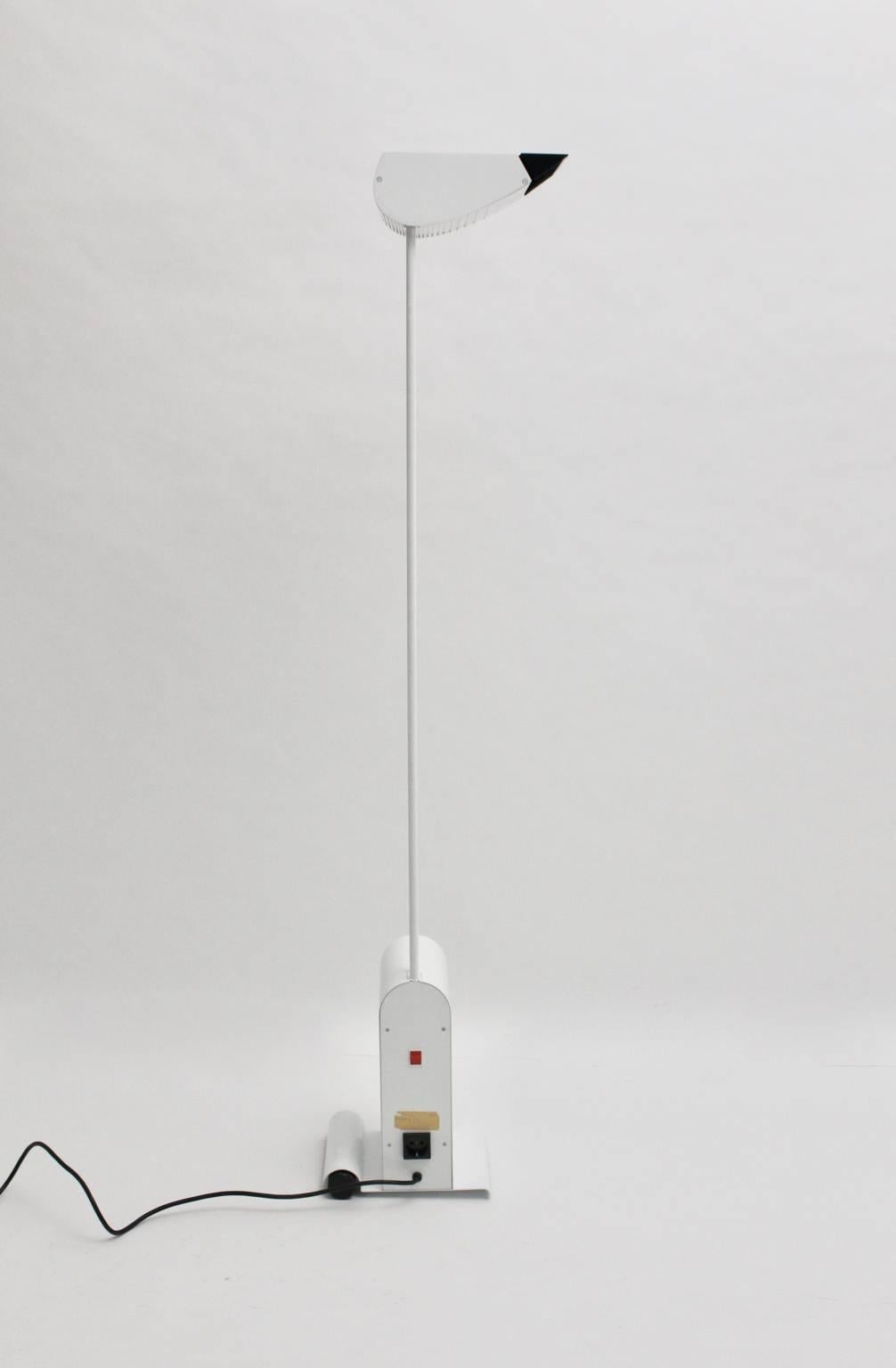 This modernist white vintage floor lamp was designed by Hartmut Engel 1985 and executed by Zumtobel.
It consists of white enameled metal and plastic and shows a movable flap on the shade.
The lamp has one roll on the base for moving.
Also the floor