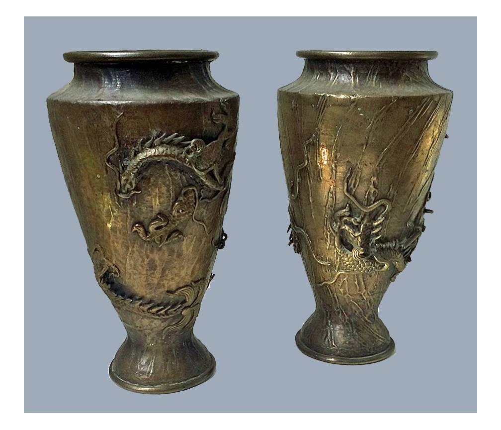 Pair of oriental bronze vases, circa 1880. Each of tapering vase shaped form, the bodies decorated with various applied sea urchins amidst a background of realistic wave like water. Measures: Height 12 1/4 inches.