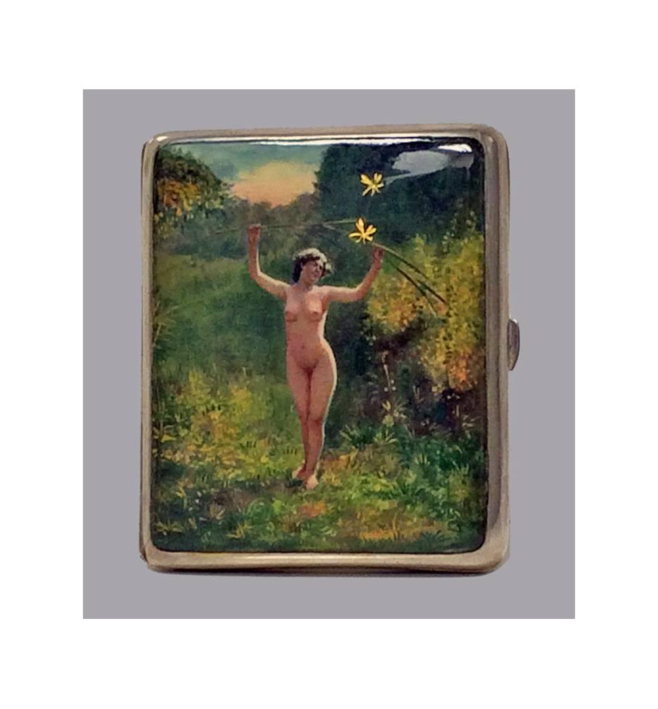 Enamel and silver erotic nude cigarette box, Continental, circa1920. The cover of the box enameled with a nude figure of a standing nude lady in a forest setting with sunset and dragon flies, arms outstretched, holding aloft branches of foliage