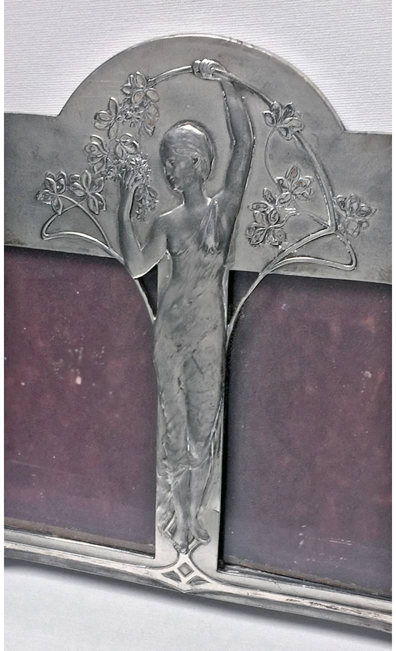 Rare W.M.F Art Nouveau double frame, Germany, circa 1900. The silvered metal frame depicting a maiden in the centre holding a floral branch, the surround of stylized Celtic design. Original back and easel. Measures: 12 ¾ x 10 inches. Images: