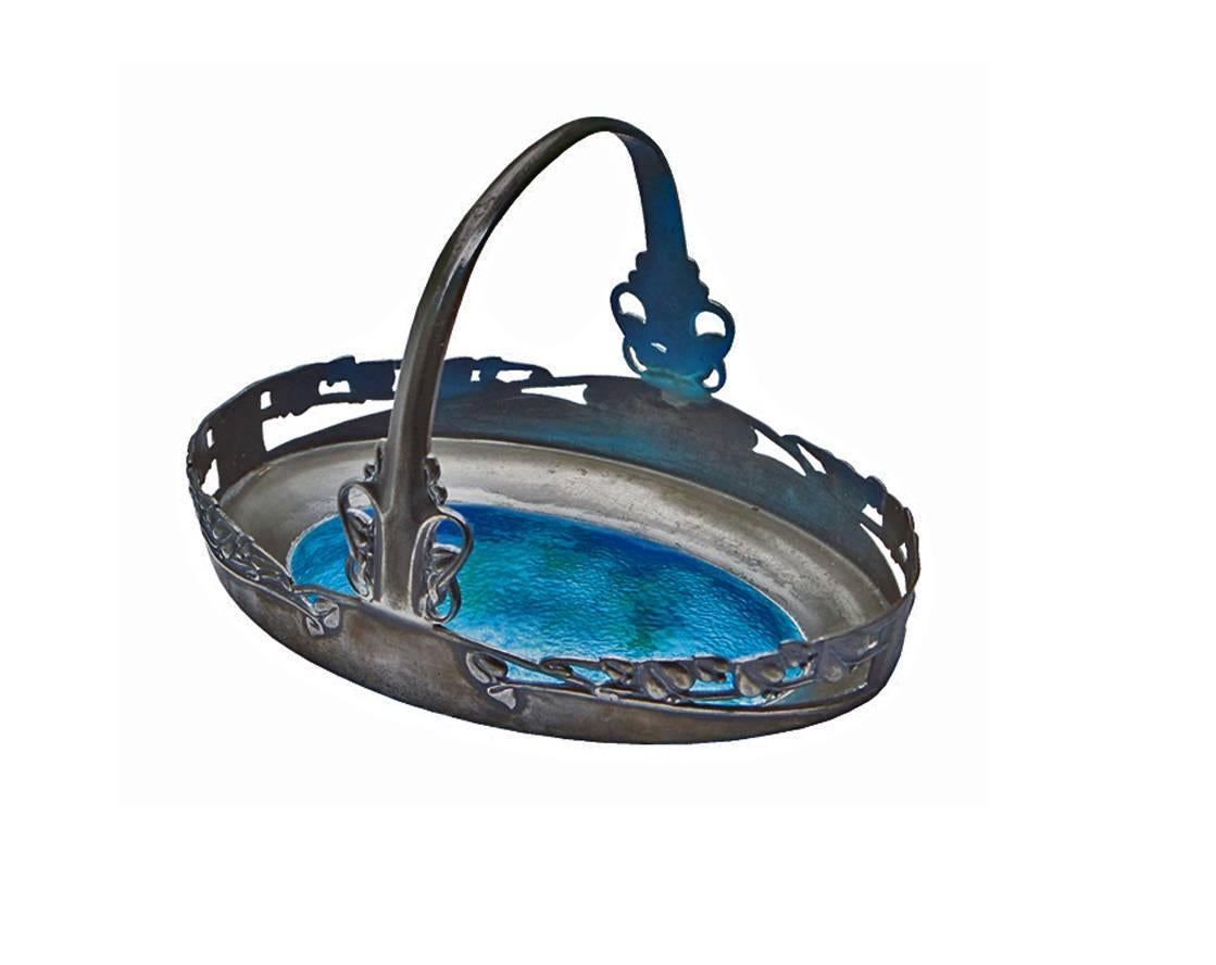 Archibald Knox for Liberty & Co, English, circa 1900. Tudric pewter and turquoise enamel basket, pierced honesty leaf decoration, open work sides and base, the handle embellished with leaves and tendrils, centred with enamel plaque stamped 'Rd.