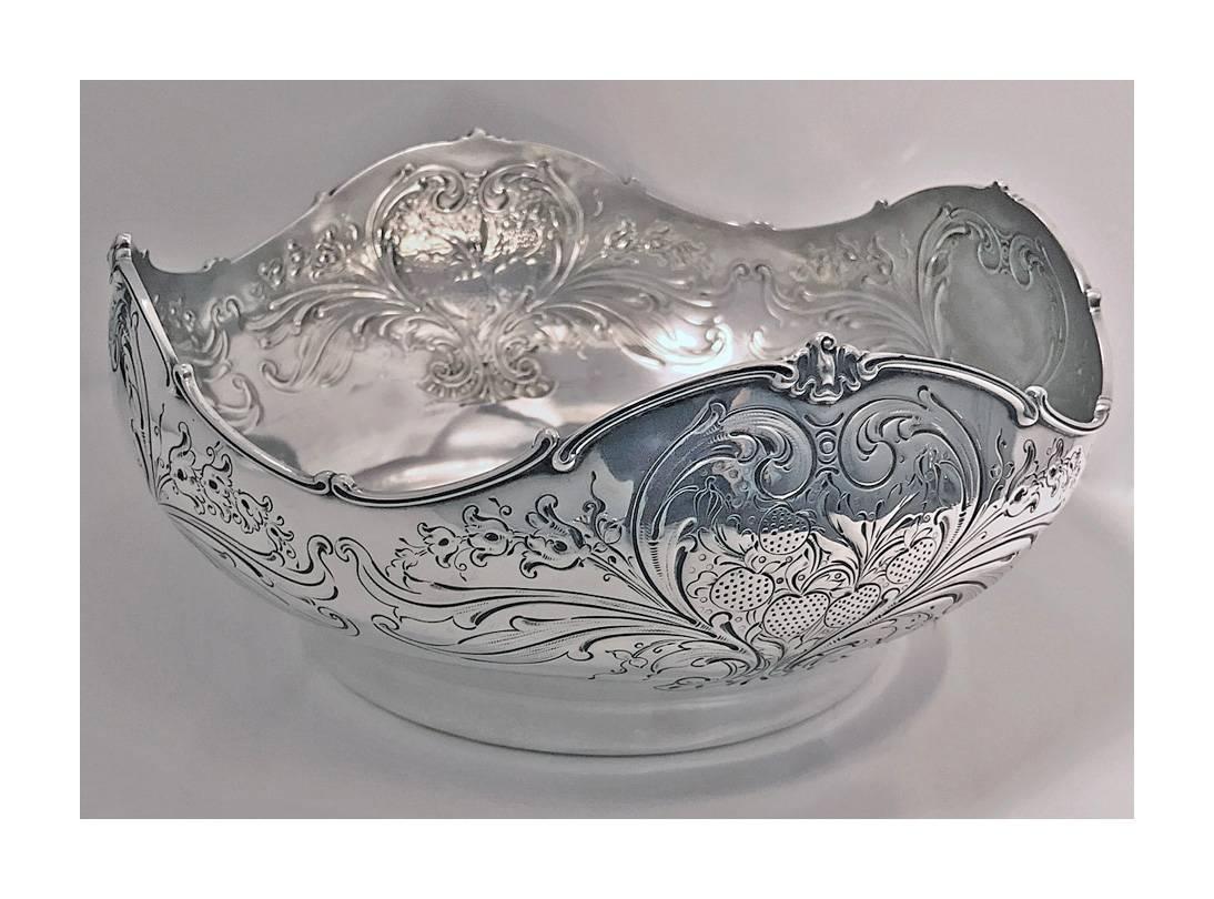 Shiebler sterling large strawberry bowl, New York, late 19th century. The bowl with lightly gilded interior of deep form, scalloped rosette interval border. The surround with alternating vacant cartouche and strawberry foliage embossed and engraved