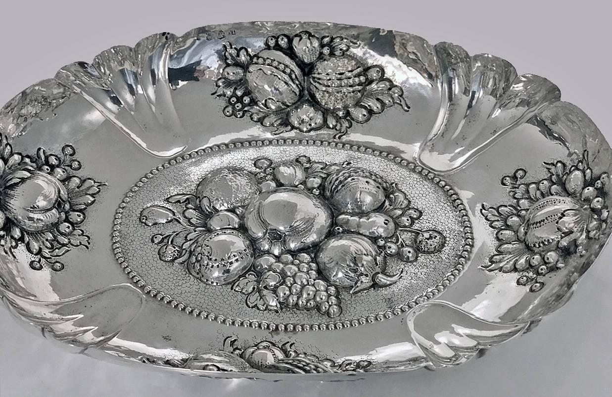 Antique 19th century German solid silver large fruit dish, circa 1880, Probably Neresheimer & Co. Oval form in the style of the 16th-17th century silver, embossed with scrolling foliage, fruits and serpent handles. The hand embossed decoration is
