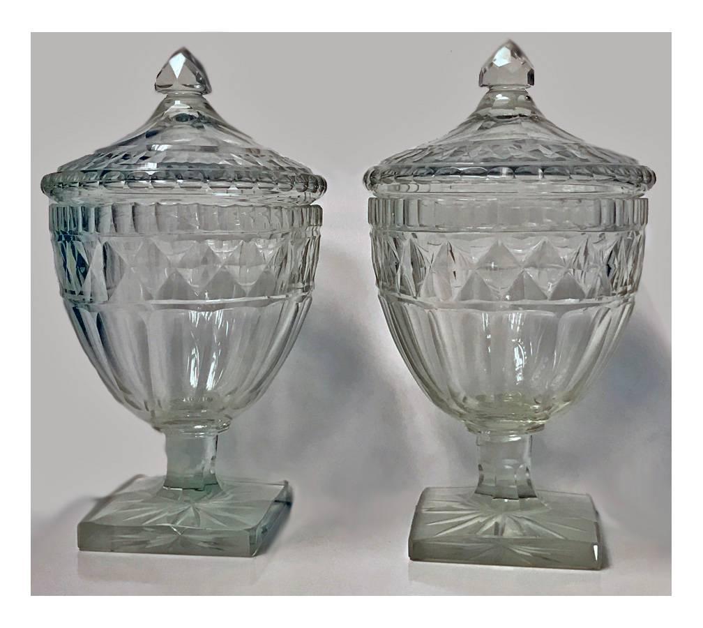Pair of George III Anglo Irish diamond cut-glass urns and covers, each cut-glass design with starburst cut bottom, stepped base and removable cover dating from the late 18th century. Good overall condition consistent with age, a few flea bites and