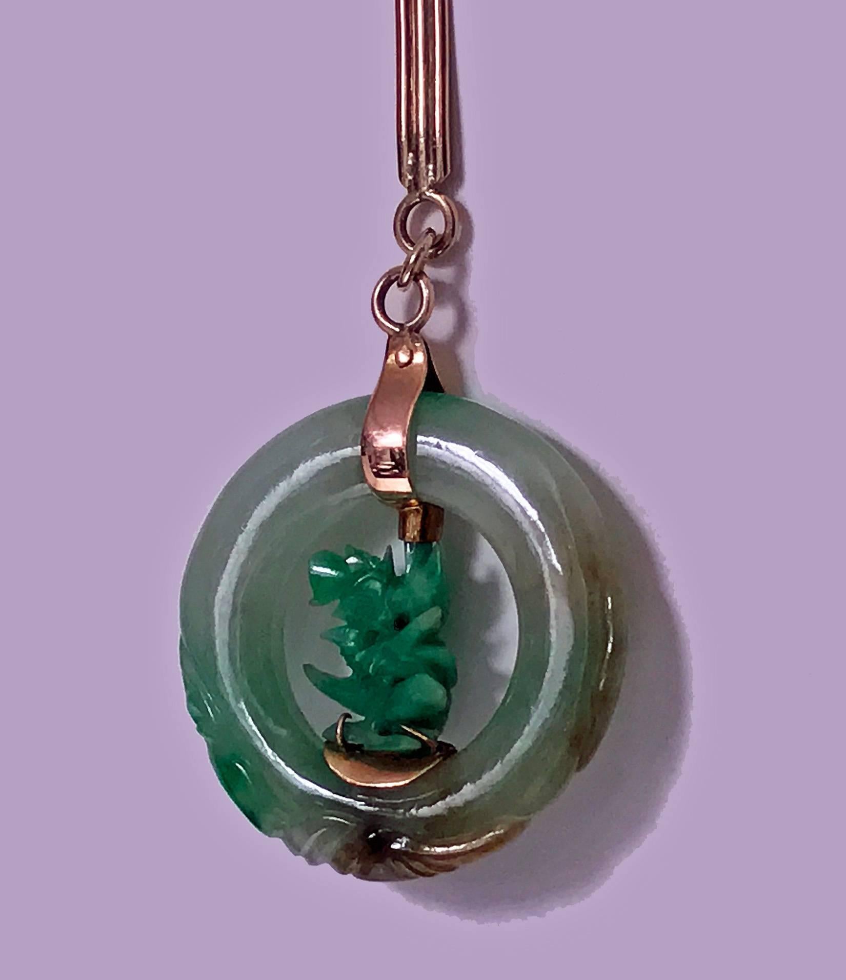 Jadeite jade circle pendant in 14-carat. Large jadeite jade circle of a white yellow green and red tones, surround carving possibly fish. Inside the jadeite circle is a carved green jadeite Jade. Excellent polish and carving. Diameter of circle: 35