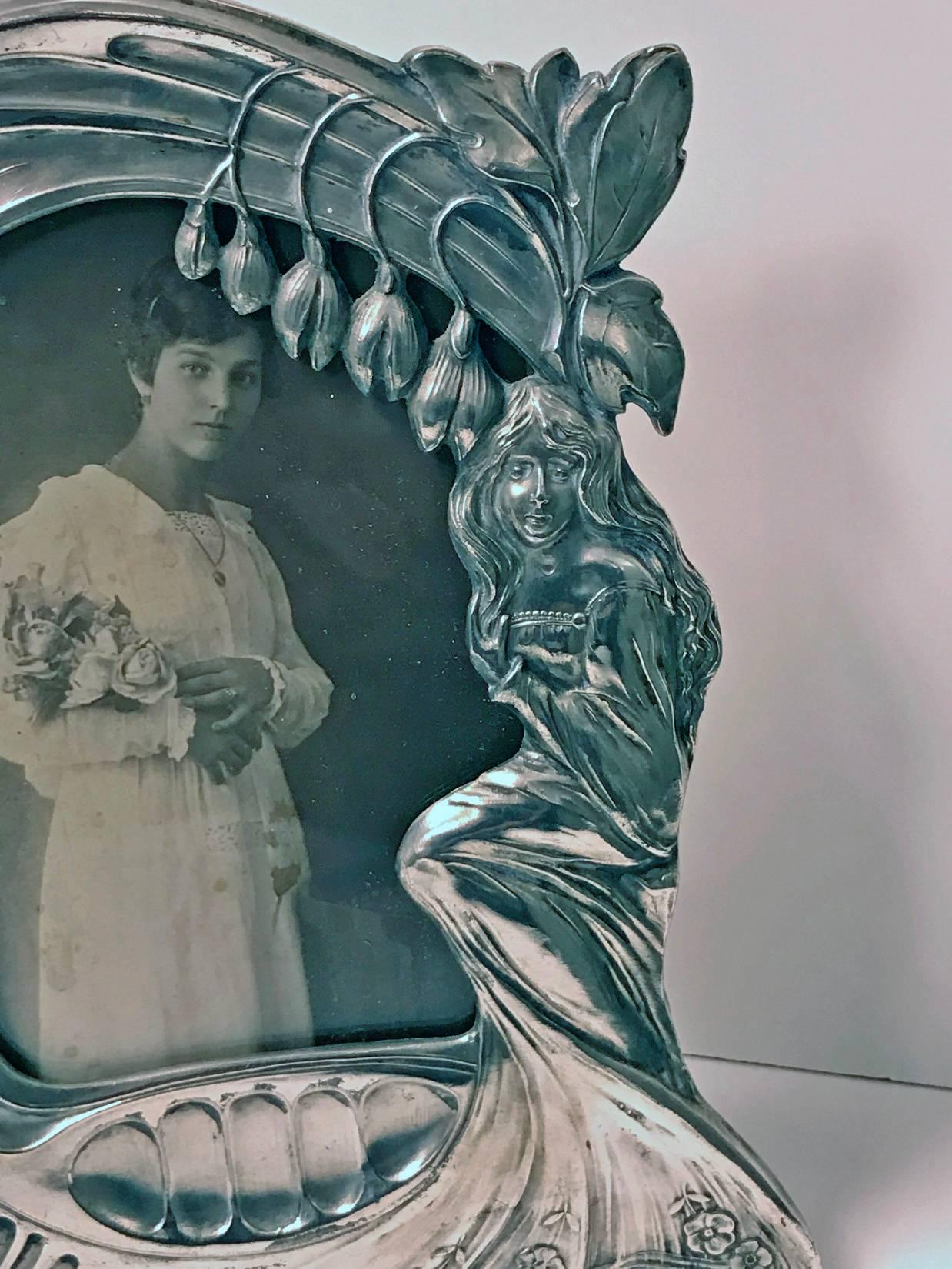 Rare design Art Nouveau pewter photograph frame, Austria, Argentor, circa 1900, stamped M.H. with eagle, Max Hacger. The frame depicting lady amidst floral decoration with flowing hair and dress. Stamped on reverse. With eagle mark MH. Overall: