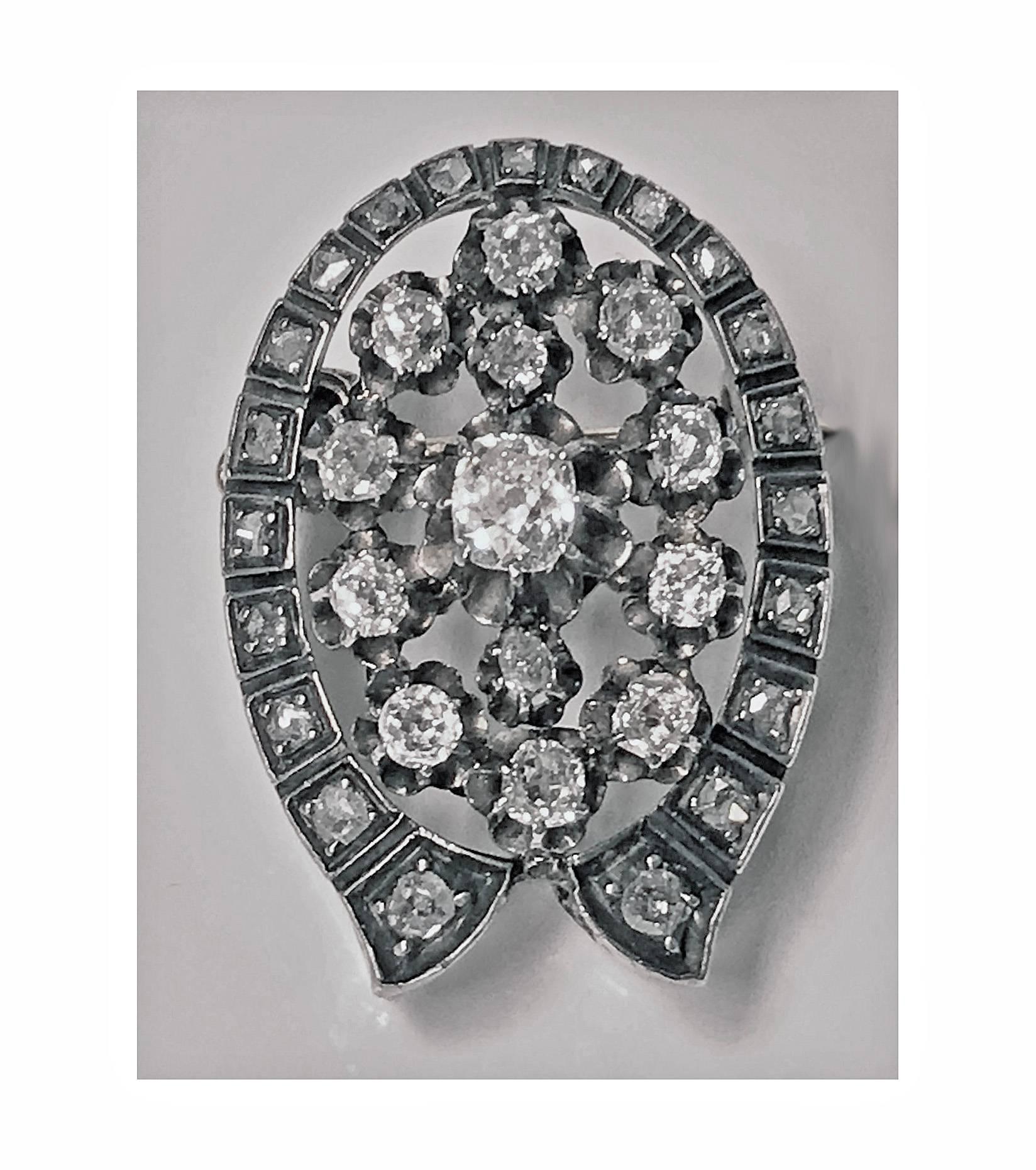 Antique 19th century diamond brooch pendant mounted in silver and 18-karat gold, France, circa 1870. Oval horseshoe shape set with 34 mixed old mine and rose cut diamonds, approximately 2.20-carat, total diamond weight, pierced gallery basket