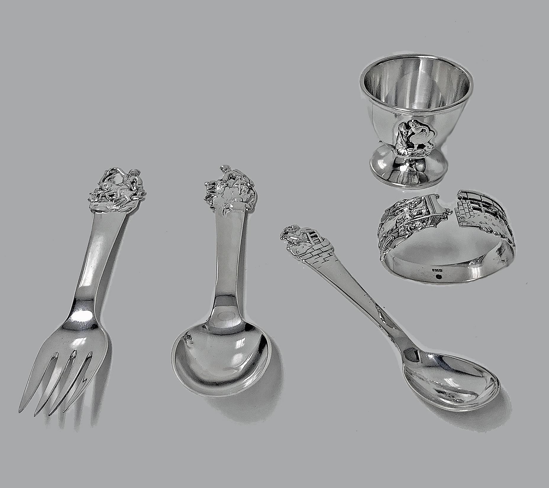Rare Danish Silver Horsens 'H.C. Andersen' fairy tale child's set, circa 1955. The set comprising fork, spoon, egg spoon, egg cup and serviette ring. All depicting various H.C. Andersen fairy tale scenes. Lengths of spoon and fork: 5.75 inches.