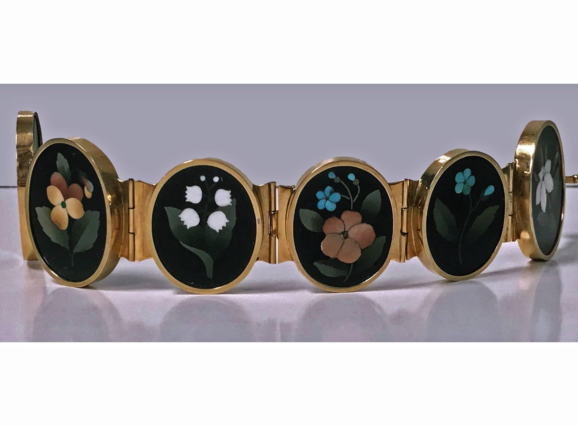 Very Fine 19th century 18K (tested) Gold Pietra Dura Bracelet, Italy C.1875. The bracelet with six slightly graduated oval bezel set pietra dura depicting foliage, berries and flowers, hinged gold links between, terminating with tongue box clasp