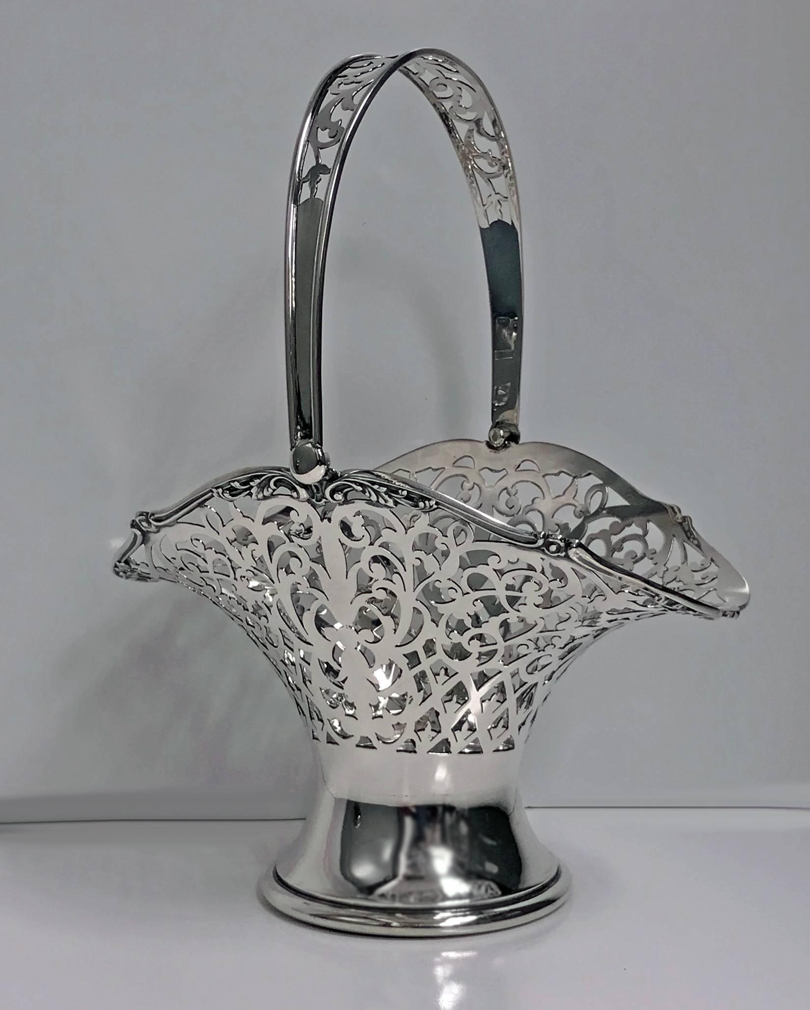 Antique sterling silver pierced basket with swing handle, Birmingham 1923, Henry Matthews. The basket with solid trumpet base rising to pierced bouquet form body, solid and pierced curved arch swing handle. Hallmarked on basket and handle. Measures: