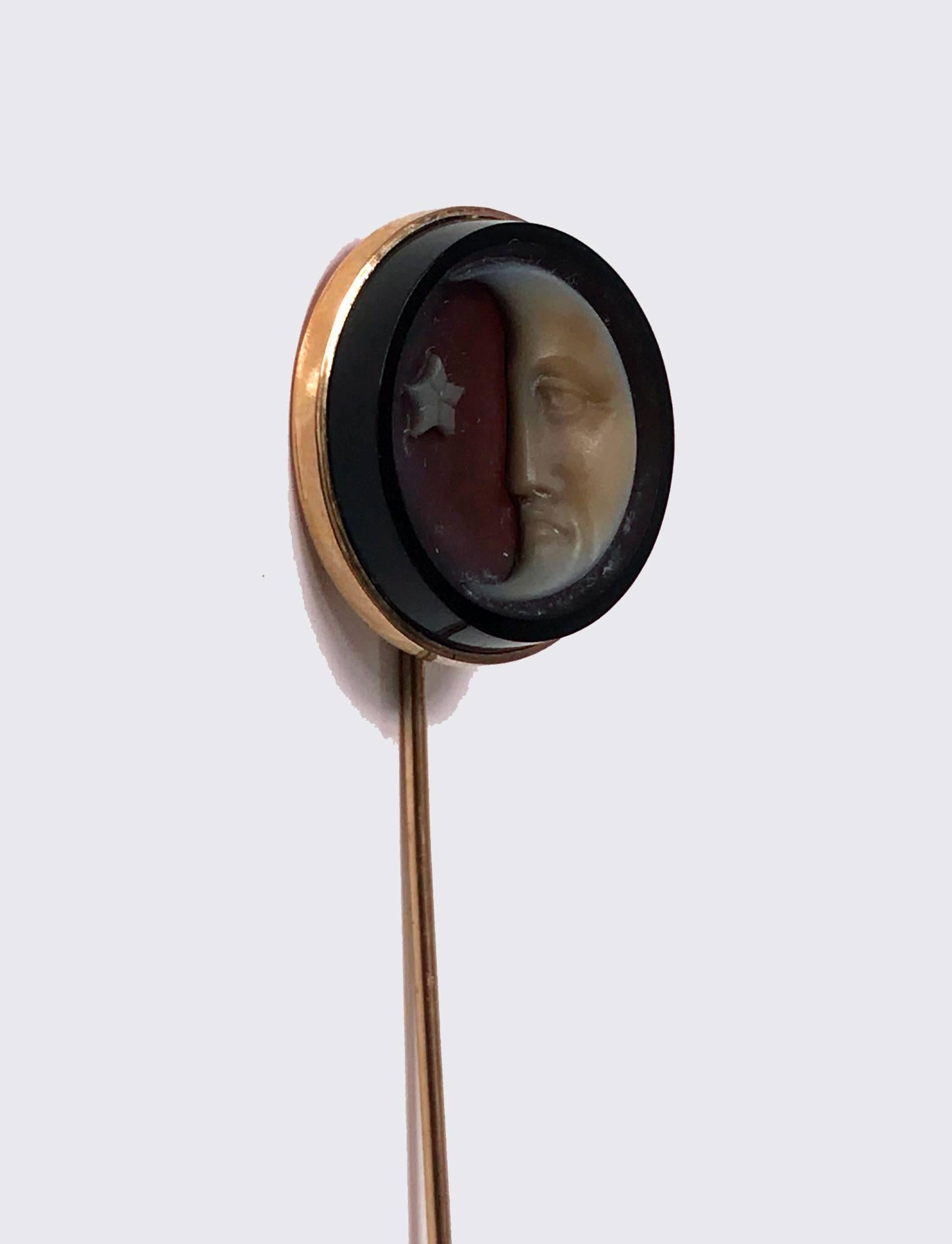 Rare antique gold and onyx cuvette stickpin, circa 1875. The stickpin, bezel set depicting the man in the moon and a star. Gold tests as 14-karat. Diameter of cuvette: Approximately 21.50 mm. Length of Stickpin: 2.25 inches. Ref: Skinners Fine