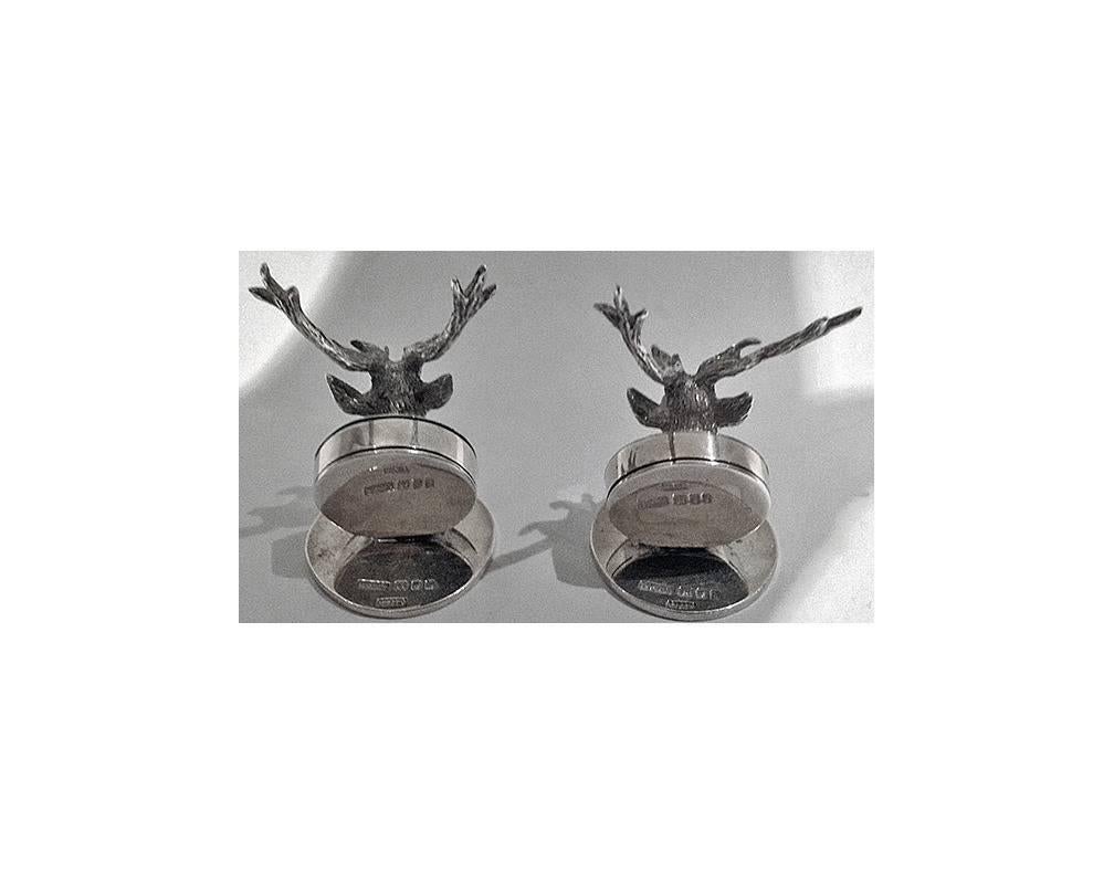 Pair Asprey English silver stag menu place card holders, London 1925. The holders of disc shape, each surmounted with a stags head inset with cabochon red eyes. Fully hallmarked and stamped Asprey. Height: 2 1/4 inches. Weight: 104 grams.
