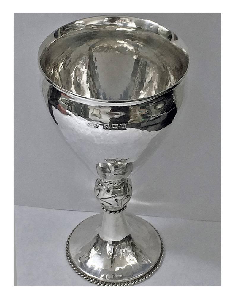 A.E. Jones hammered Sterling Silver Goblet, Birmingham 1909. The goblet of plane hammered decoration on pedestal foot, with rope border surround rising to foliate knopped stem and vase shape vessel, everted rim. Full silver hallmarks and retailers