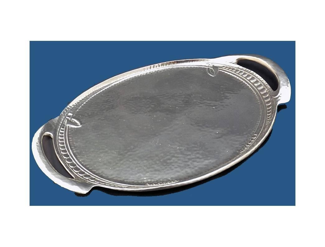 Rare Archibald Knox Liberty & Co Tudric Tray, C.1905. The polished pewter tray of plain punch bead hammered finish with stylised whiplash accents. Measures: 14 x 10 inches. Liberty Tudric marks to base and numbered 0311