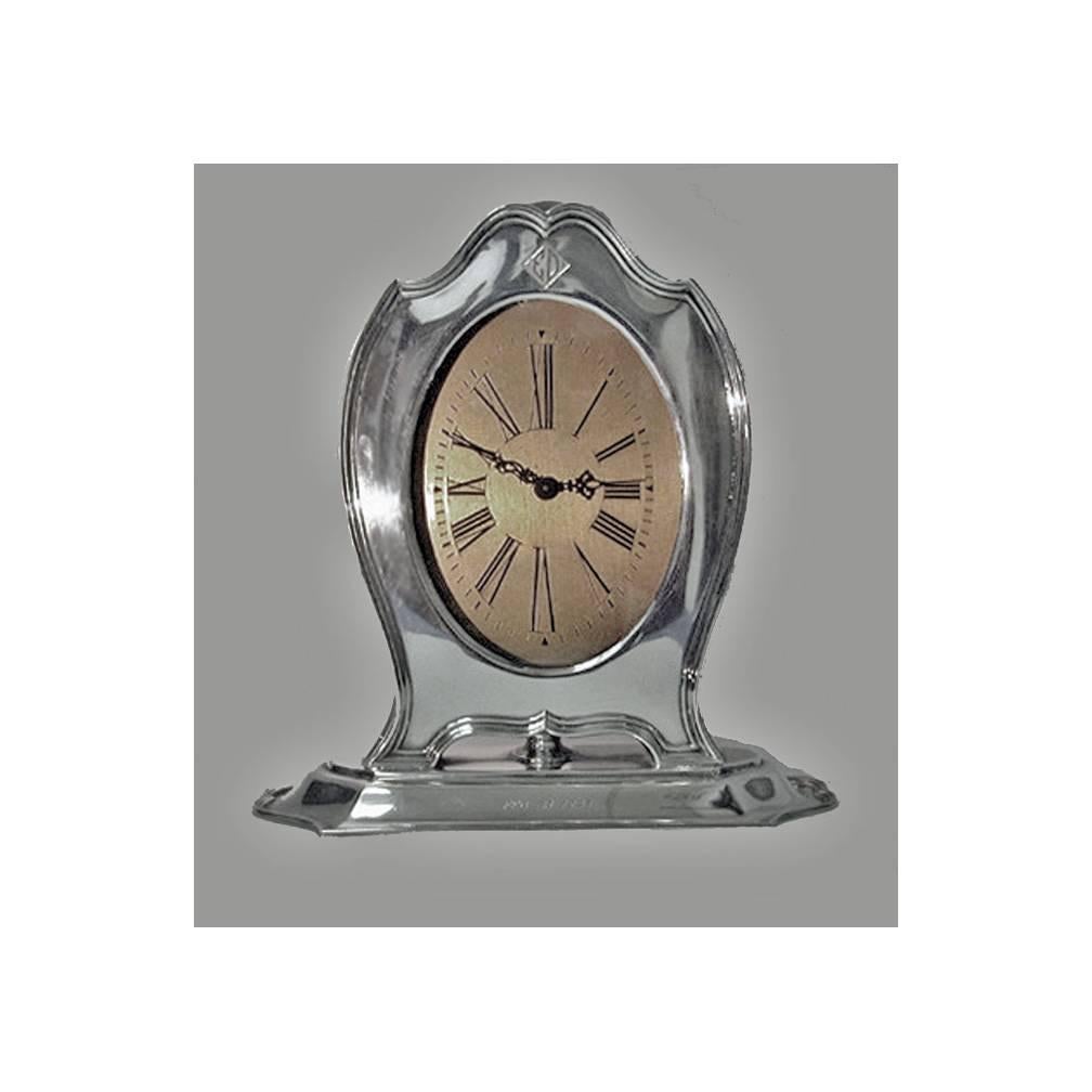 American Art Deco sterling clock, Reed & Barton, circa 1920. The large clock on elongated reeded base supporting silver slightly shield shape clock, gold dial, roman numerals. The sterling mount with monogram ED in Art Deco style and engraved on