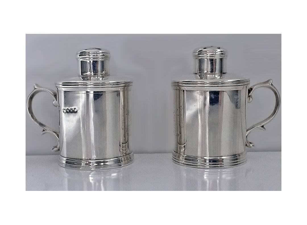 Pair of antique silver pepper pots in the form of Tankards, London 1885, Martin Goldstein. The peppers of plain style, crested with a unicorn’s head, upper and lower reeded borders, double scroll handles. The detachable covers with pierced swirl