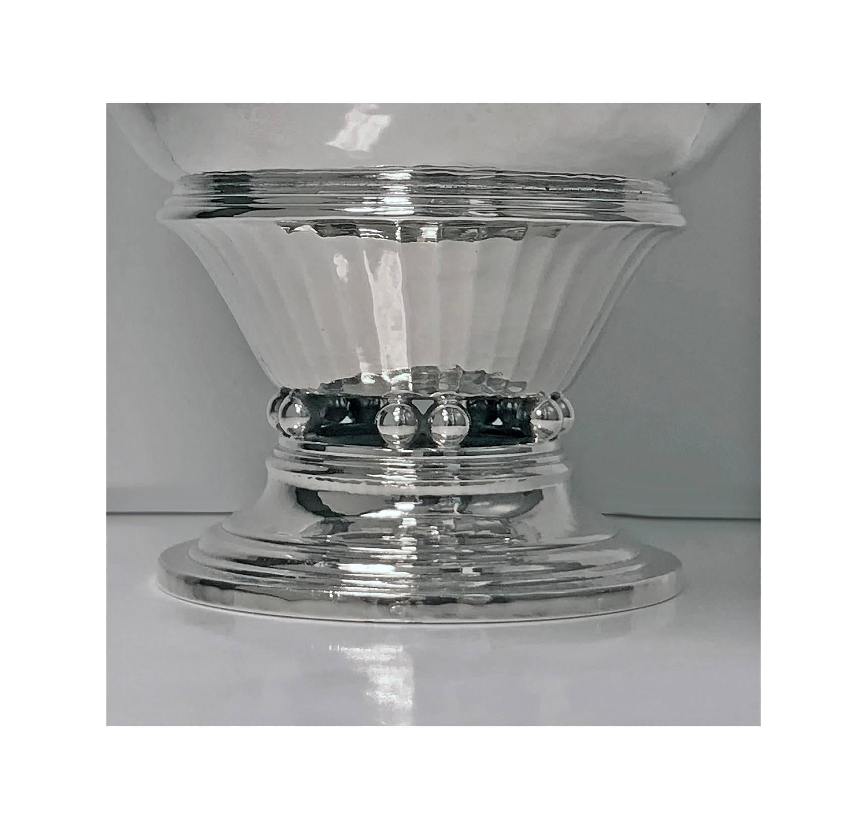Anton Michelsen hammered silver bowl, Denmark, 1918. The circular bowl in Jensen style on stepped circular foot, on an openwork band of ball supports supporting tapered panelled surround with moulded rim, plain body, with a flared rim. Measures: