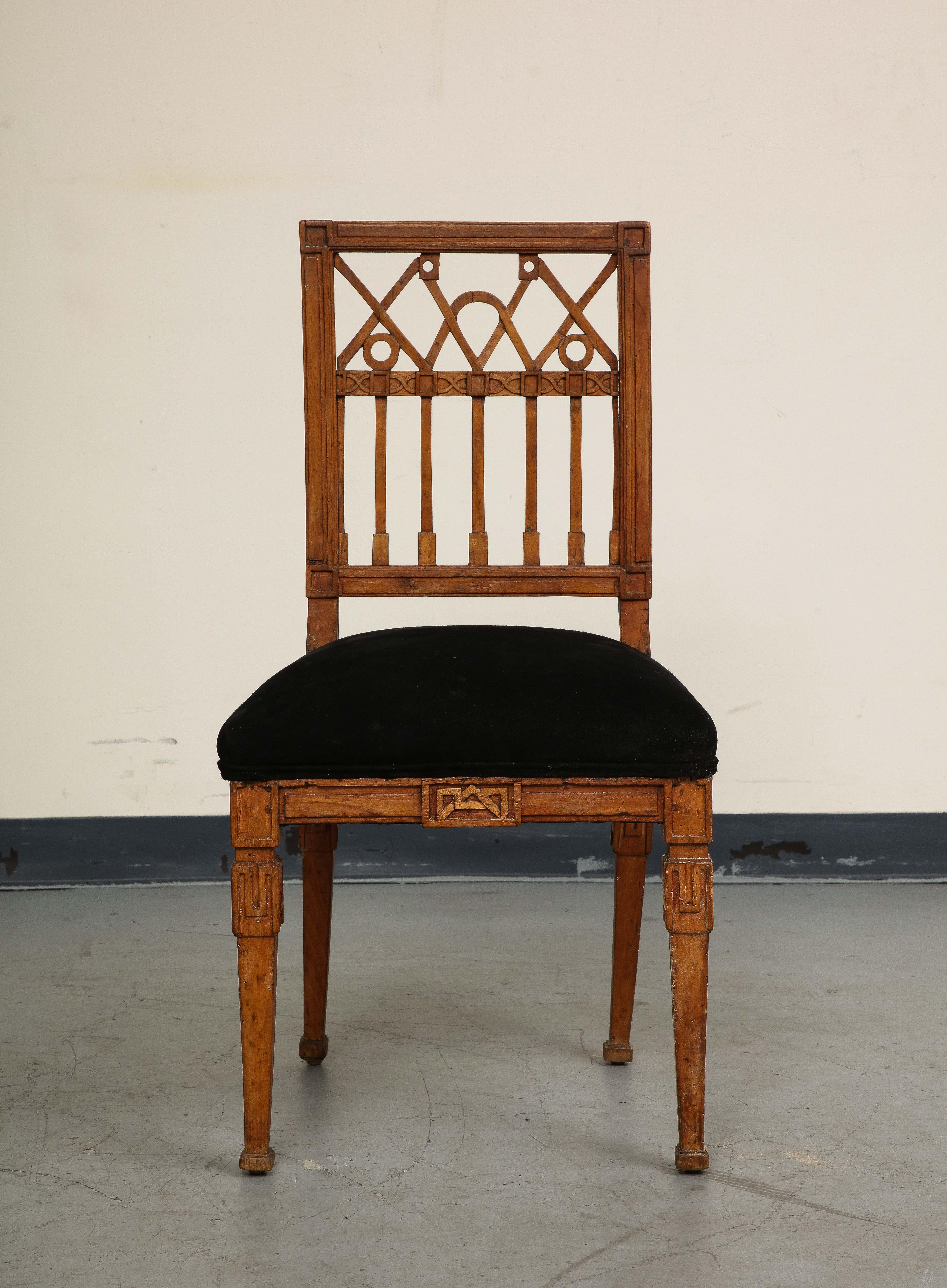 French neoclassical style carved oak side chair, with pierced back above the padded seat and rising on tapered legs. Seat has been newly reupholstered in black suede. 
