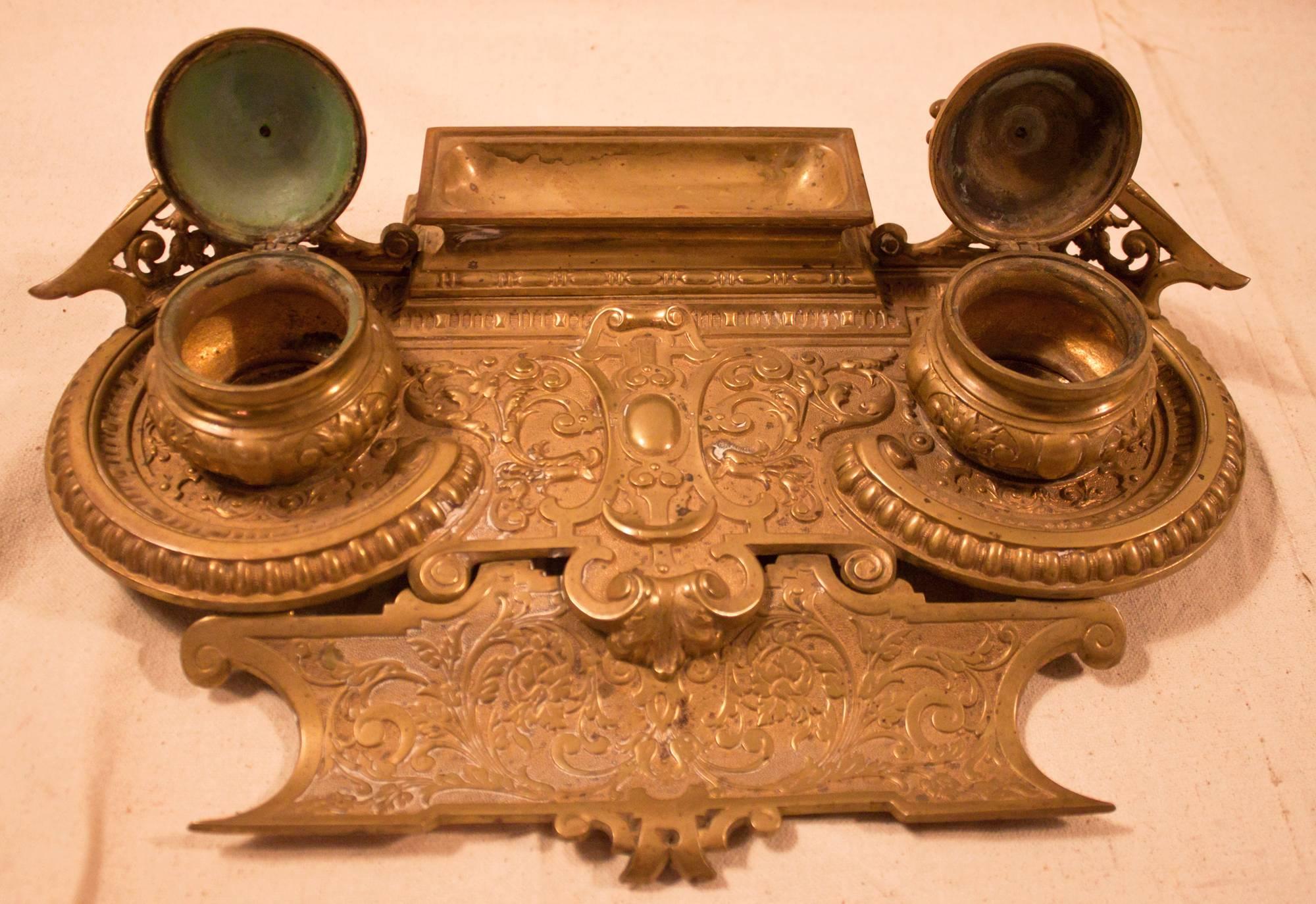 Bronze inkwell intricately embossed with scroll work. Features include a pen vest and back tray and double inkwells with griffins on the back gallery. A continental piece possibly Austrian or German made for the French market with very detailed and
