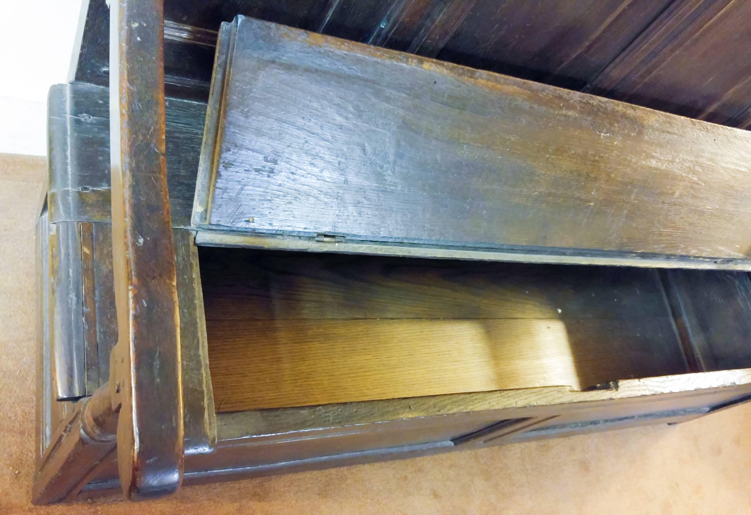 Jacobean English oak box settle with high paneled back. Hinged seat lifts for storage.