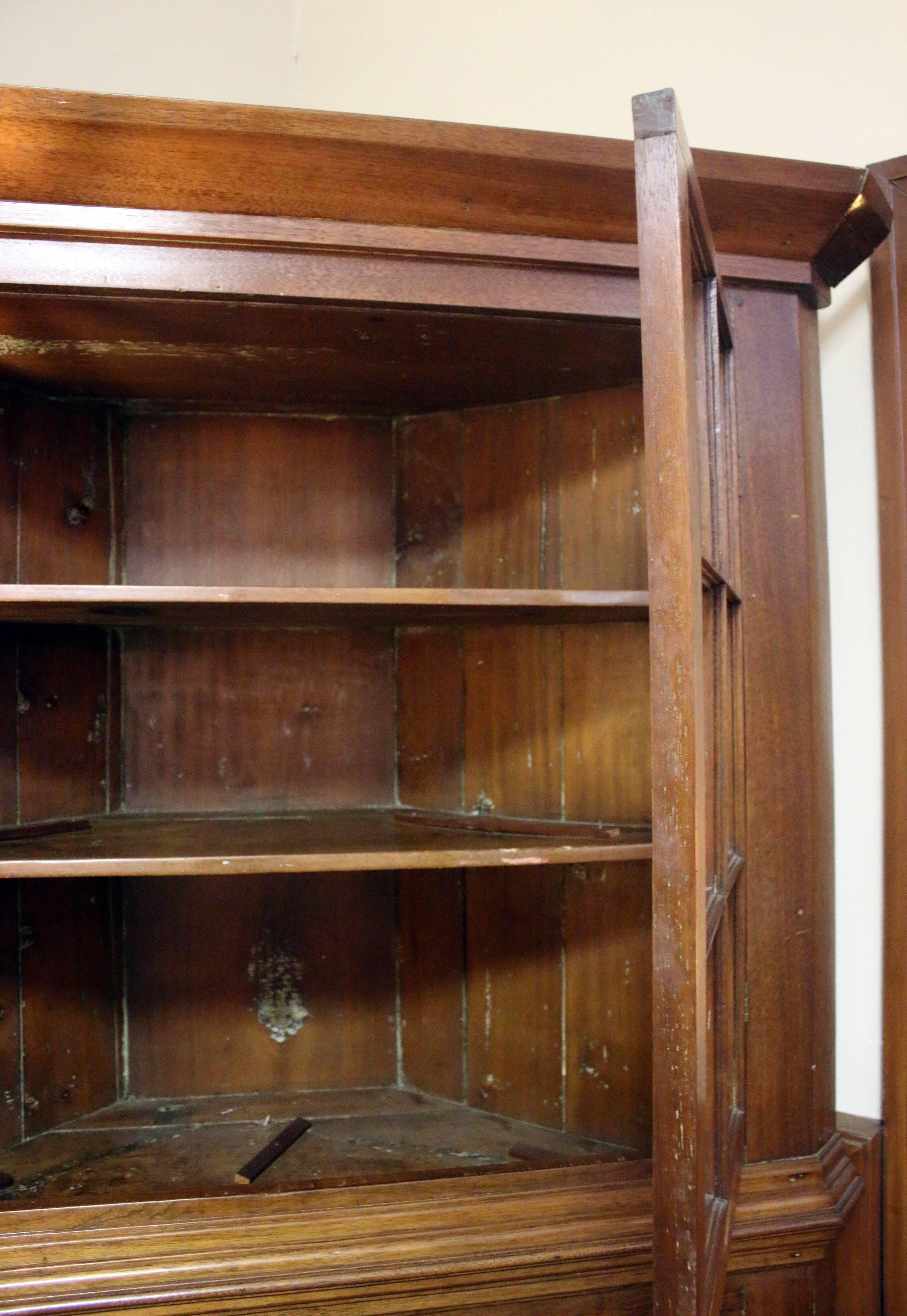 Primitive walnut corner cupboard from the mid Atlantic region. The 12 panes of old wavy glass appear to be original. There is no evidence that it ever had hardware, but the doors open and shut perfectly and the outer finish is original. The interior