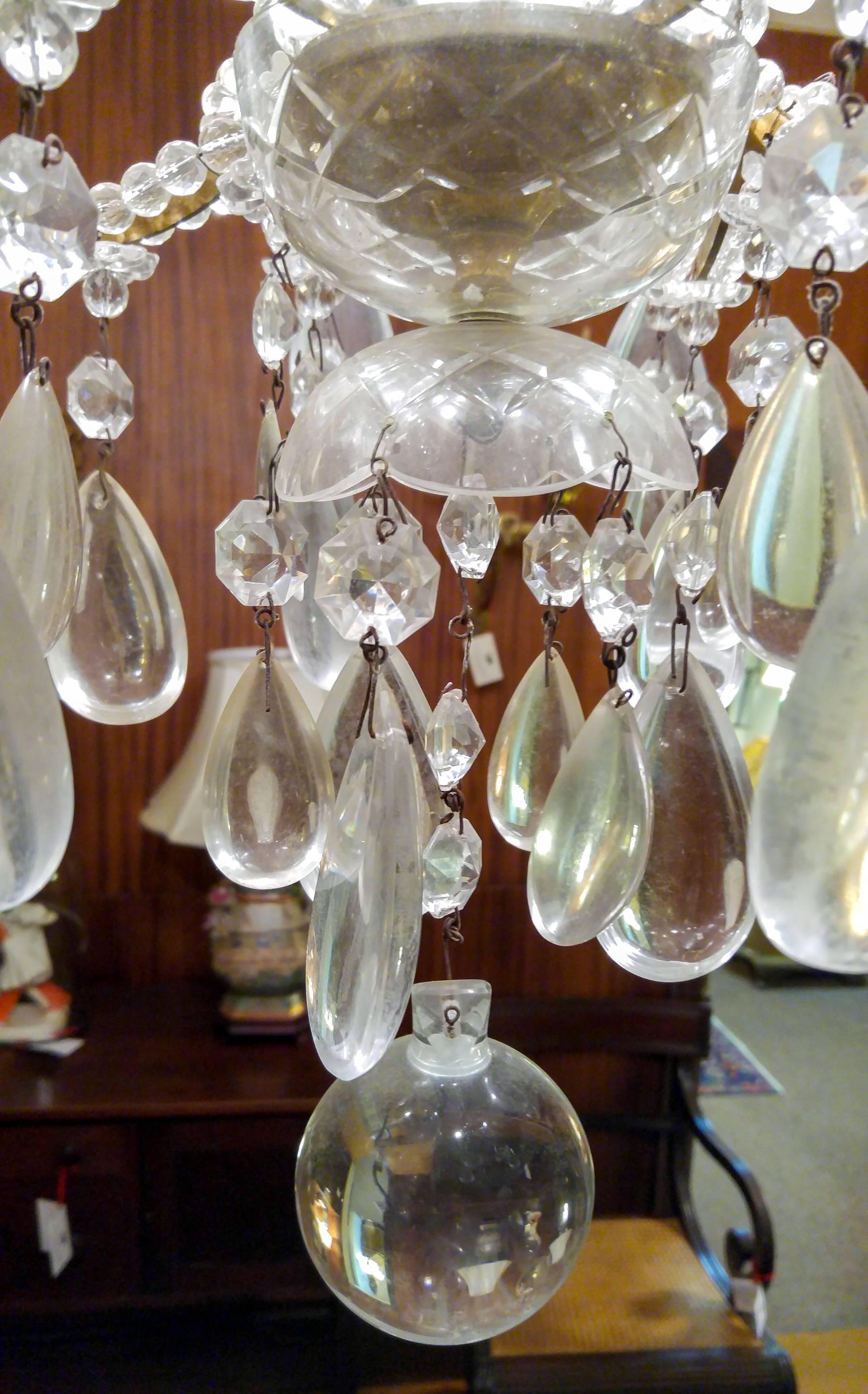 Ornate French crystal chandelier featuring an elaborate center vase column, very large teardrop prisms ( 3.25 inches tall ), fancy rosettes and a round crystal pendant. The eight arms are flanked by glass beaded chains. Gorgeous shower effect at