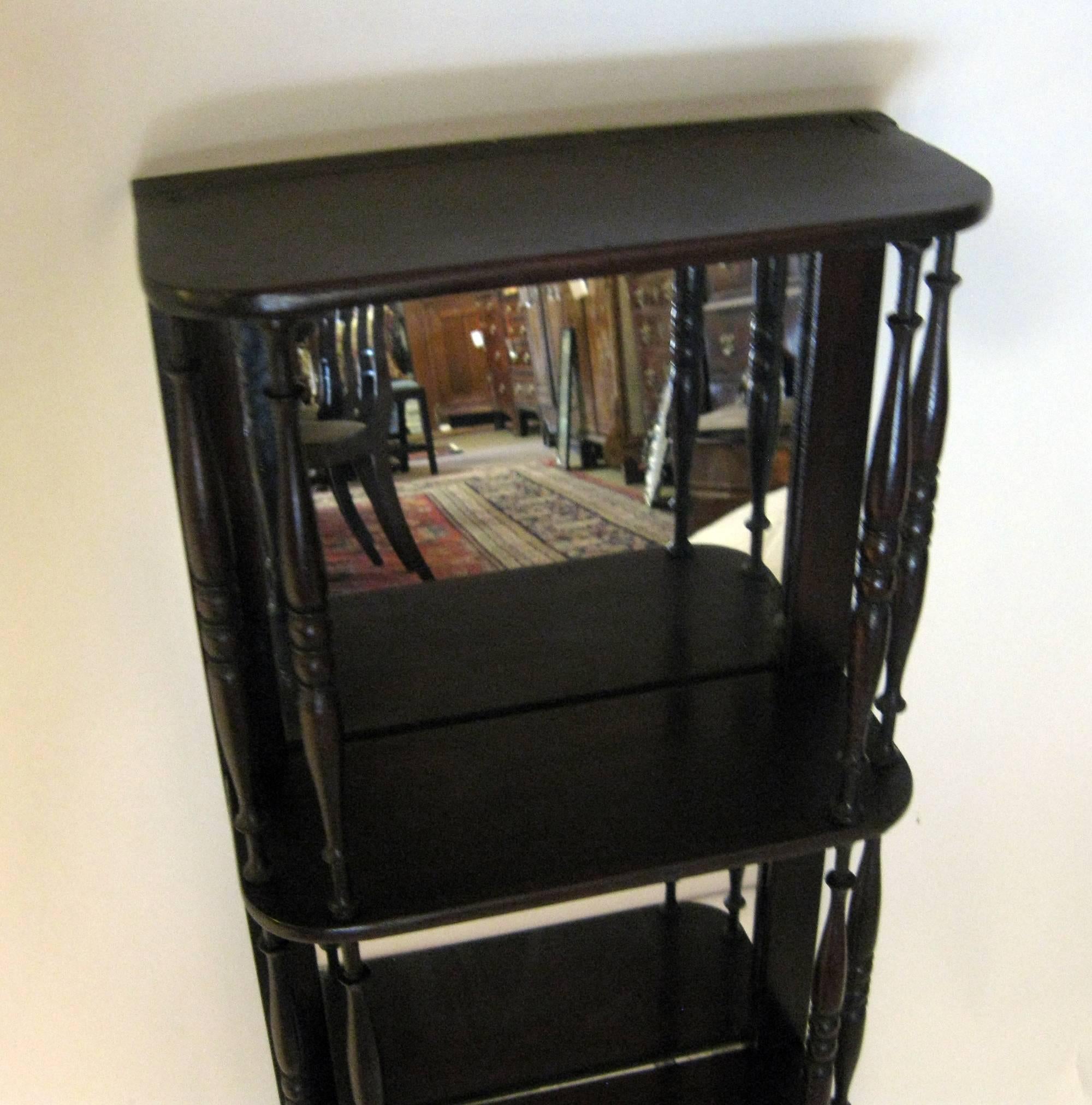 Pair of late 19th century hanging mahogany shelves in the Sheraton style. Featuring very delicately turned spindles and mirrored backs. Brass hangers are attached to either side of the tops.
See measurements below.