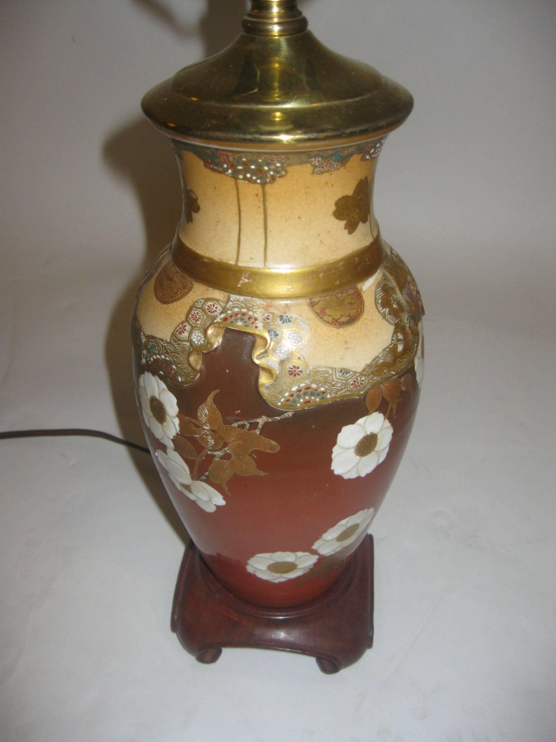 Diese schöne japanische Vase aus Satsuma-Porzellan, die in der Meiji-Zeit für den europäischen Markt hergestellt wurde, wurde in eine Tischlampe umgewandelt und auf einen Holzsockel montiert. Der mit zarten Blüten verzierte, emaillierte und