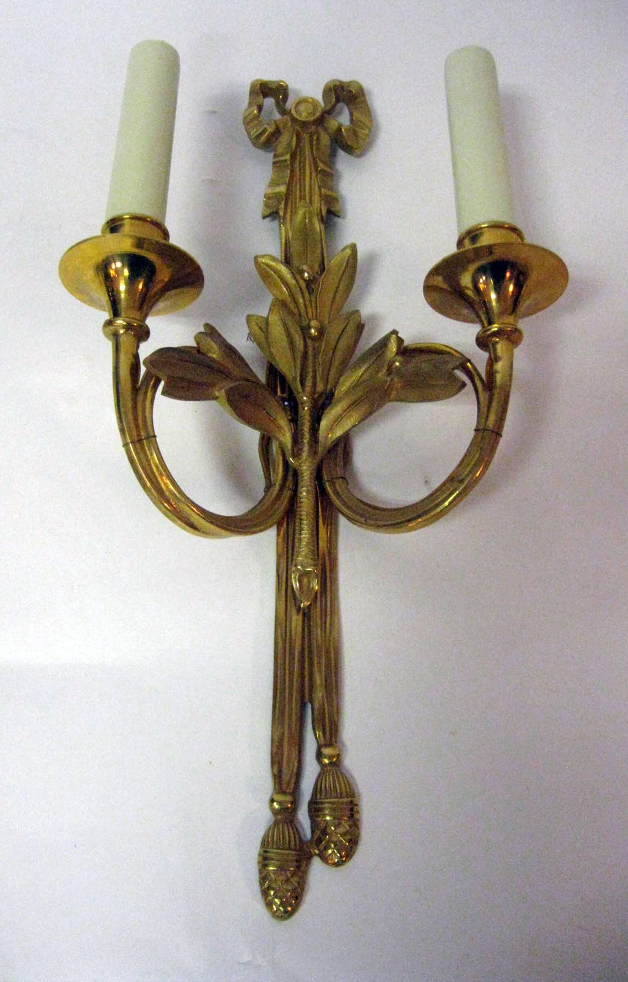 Four gold gilded bronze French wall sconces. Featuring all the bells and whistles; laurel clusters, pine cones and graceful ribbons and bows, they would make a lovely addition to any room. Wired and ready to be installed. See measurements below.