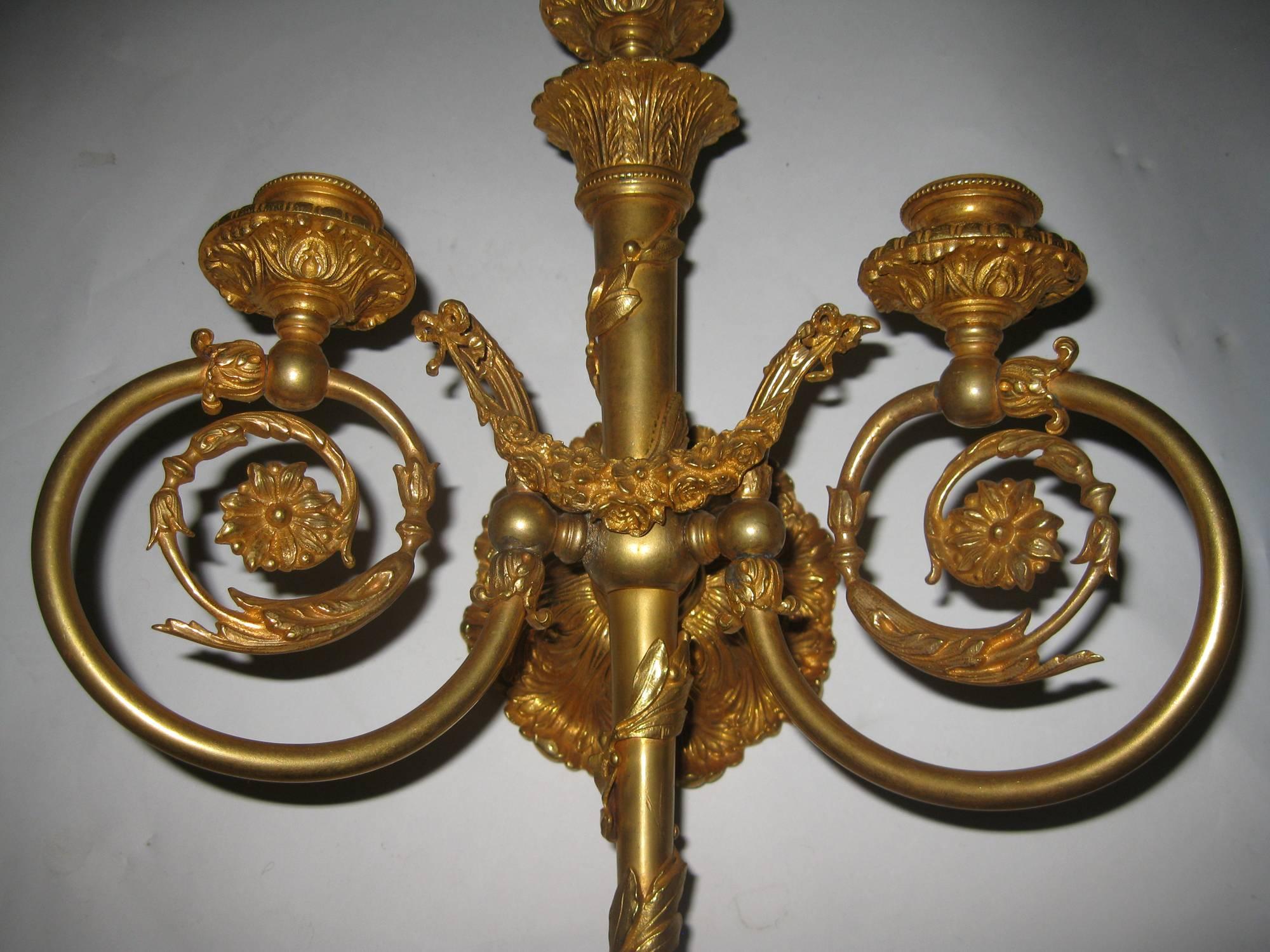 Pair of bronze doré wall sconces featuring incredible detailed ormolu including festooned floral garlands, ribbons and tiny bow embellishments. Triple candle holders. Drilled for wiring. See measurements below.