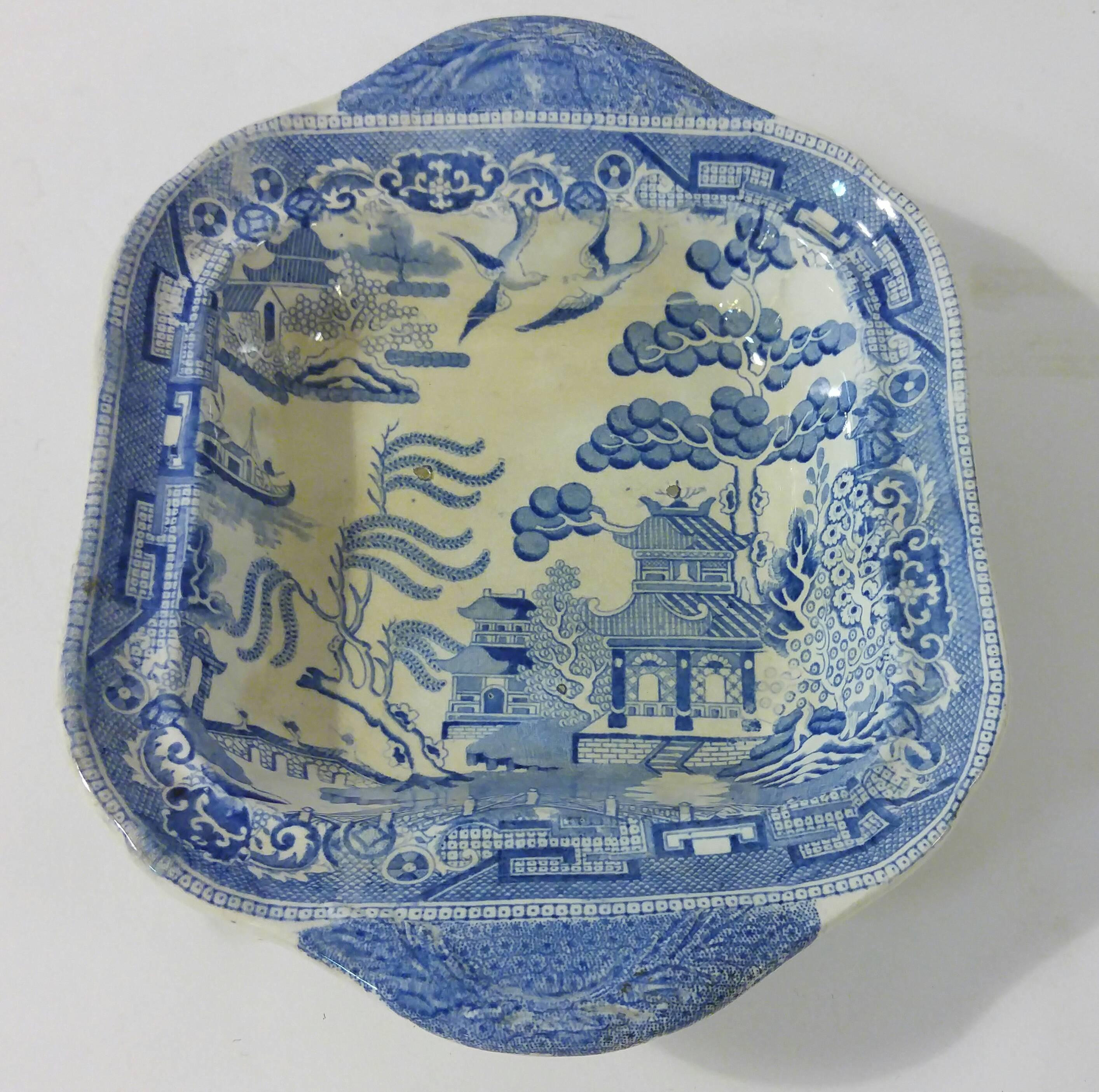 19th century English transfer-ware lidded vegetable dish in the blue willow pattern. The bowl features handles on either side with a deep lid with decorative finial knob.