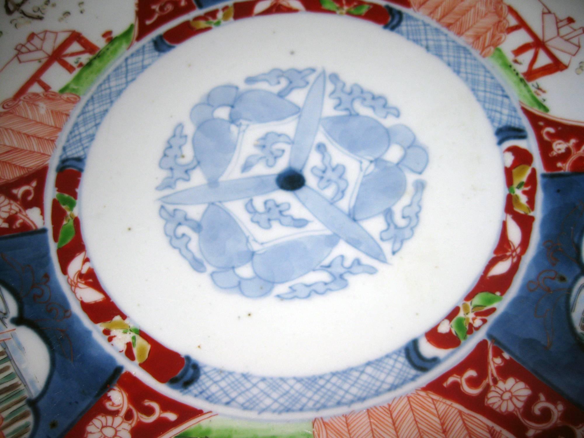 Petite Imari charger featuring a center medallion with butterflies. The edges are painted with intricate geometric, floral and bird motifs in lovely pale colors. Designs painted on back of charger as well.
